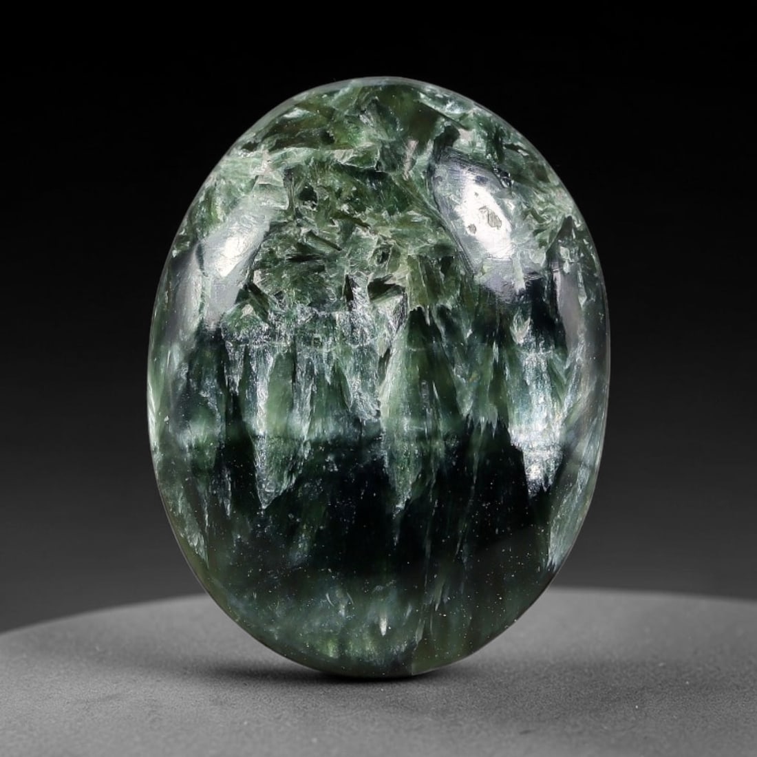 14.65 Carats Natural Deep Green Siberian Seraphinite Polished Cabochon, 32TZ: This is a fully natural polished seraphinite specimen sourced from Siberian deposits, displaying distinct feathery fibrous inclusions that create beautiful flowing chatoyant patterns across its smooth