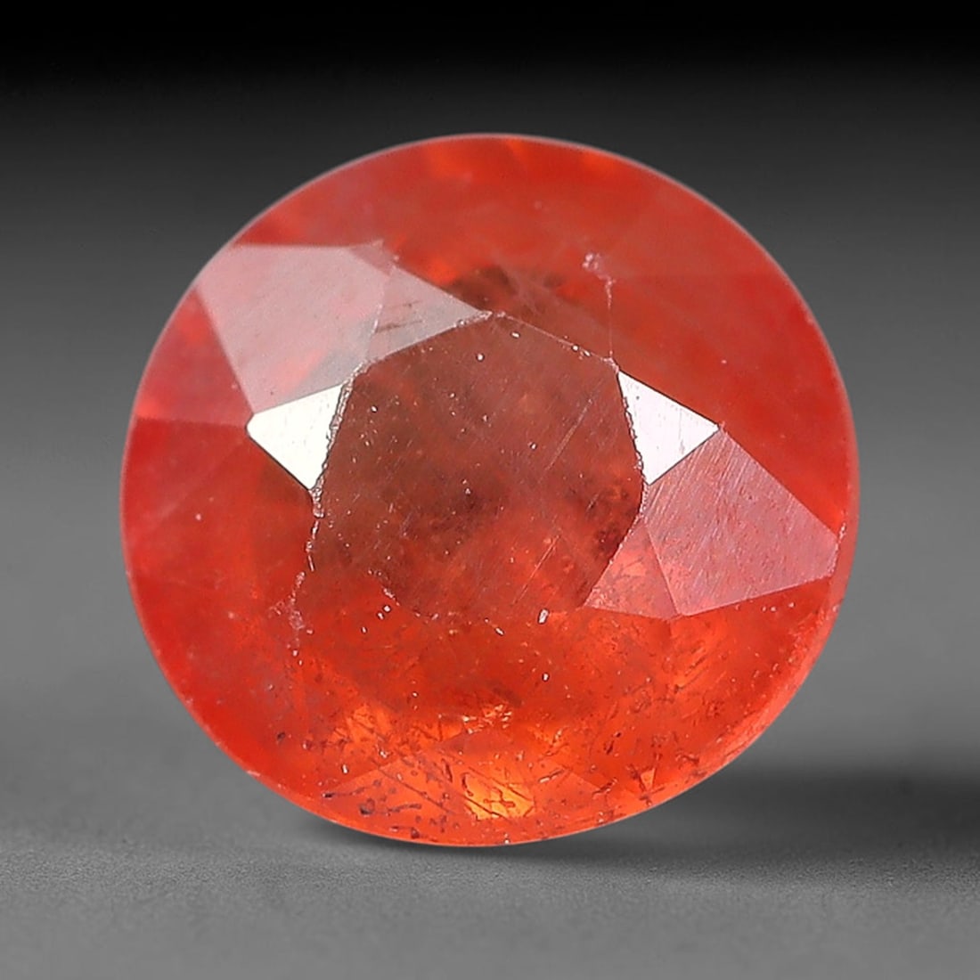 0.85 Carats Natural Orange Sapphire Round Faceted Loose Gemstone, 85YW: This natural orange sapphire is fashioned in a classic round brilliant faceted cut, presenting soft warm orange hues consistent with natural corundum specimens. Fine scattered mineral specks and faint