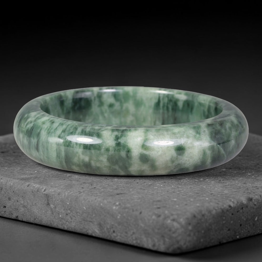 Natural Burmese Type A Variegated Floating Green Jadeite Jade Bangle Bracelet, 90TD: Highly polished jadeite bangle featuring striking variegated deep green swirling patterns over a pale translucent base. Inner dimension 61.5x16.3mm, thick wide rounded band with glossy smooth finish. 