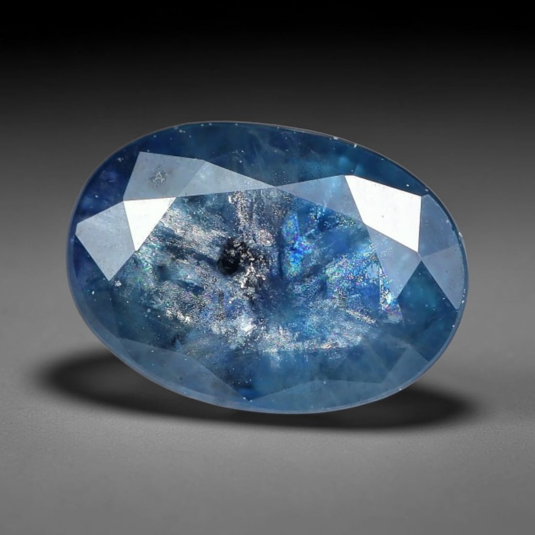 1.07ct Natural Blue Sapphire Oval Loose Gemstone, 38TY: This natural oval faceted blue sapphire with exact dimensions of 6.8x4.8x3.6mm. It displays a rich, saturated cool steel-blue hue accented by faint violet undertones, brought to life by expertly polis