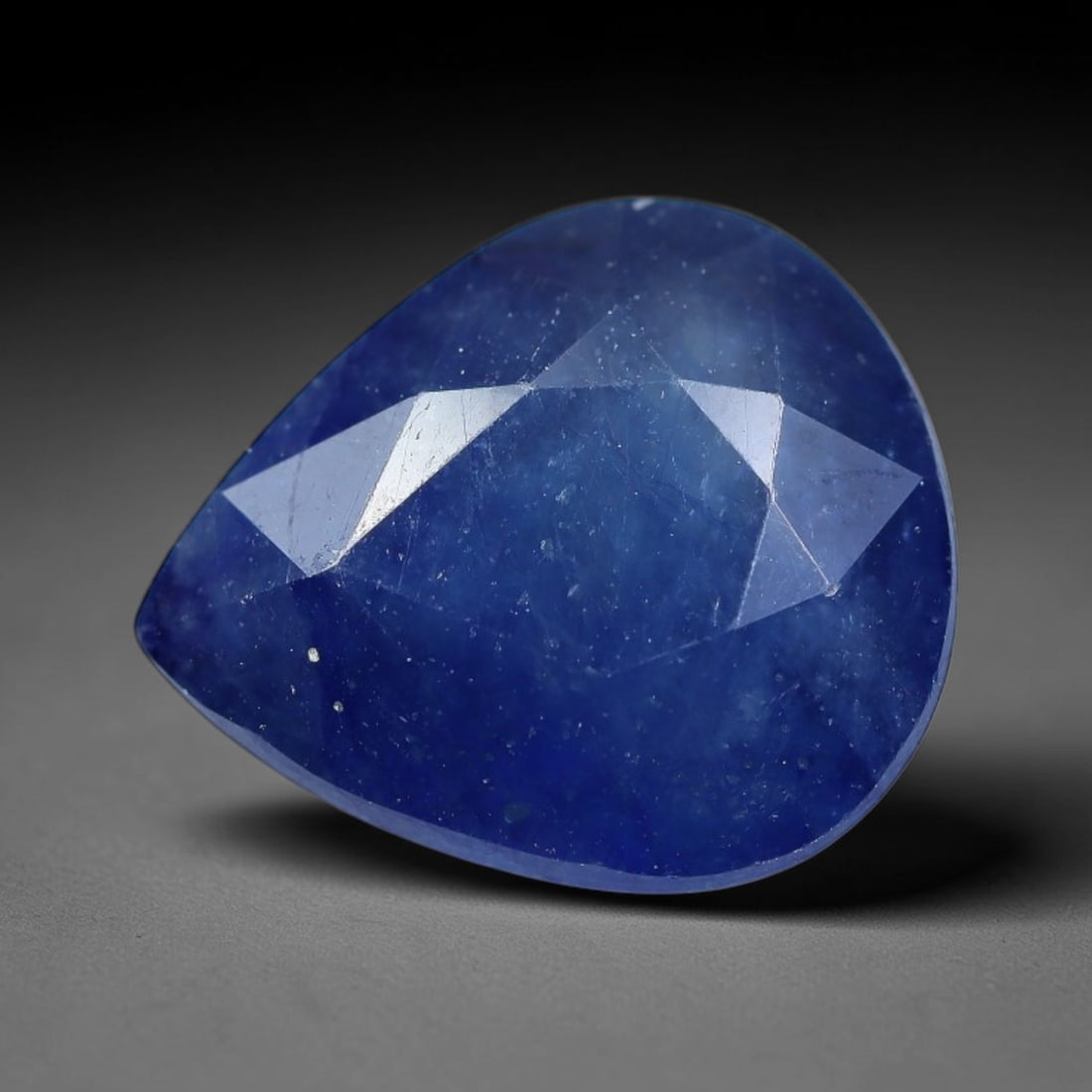 7.20 Carats Royal Blue Sapphire Pear Cut Loose Gemstone, 84TY: This neat pear cut sapphire showcases deep, saturated royal blue color, enhanced by clean reflective step facets. Natural internal fine fissures and scattered tiny mineral specks can be observed withi