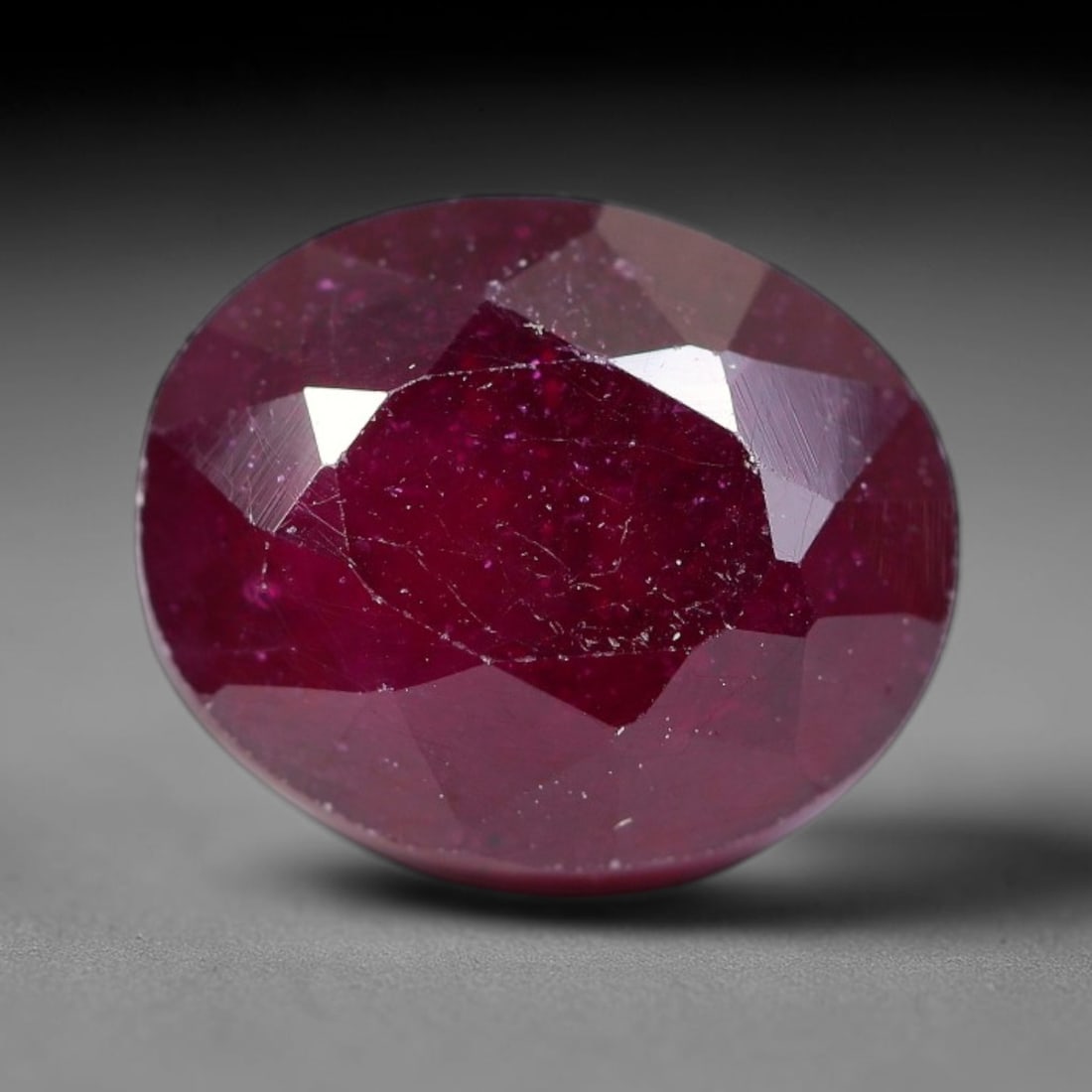 5.96 Carats Natural Madagascar Ruby Oval Faceted Loose Gemstone, 1SA: This sizable natural Madagascar ruby is cut into an oval brilliant faceted form, showcasing rich saturated crimson red hue characteristic of Malagasy corundum. Extensive natural internal silk veining,
