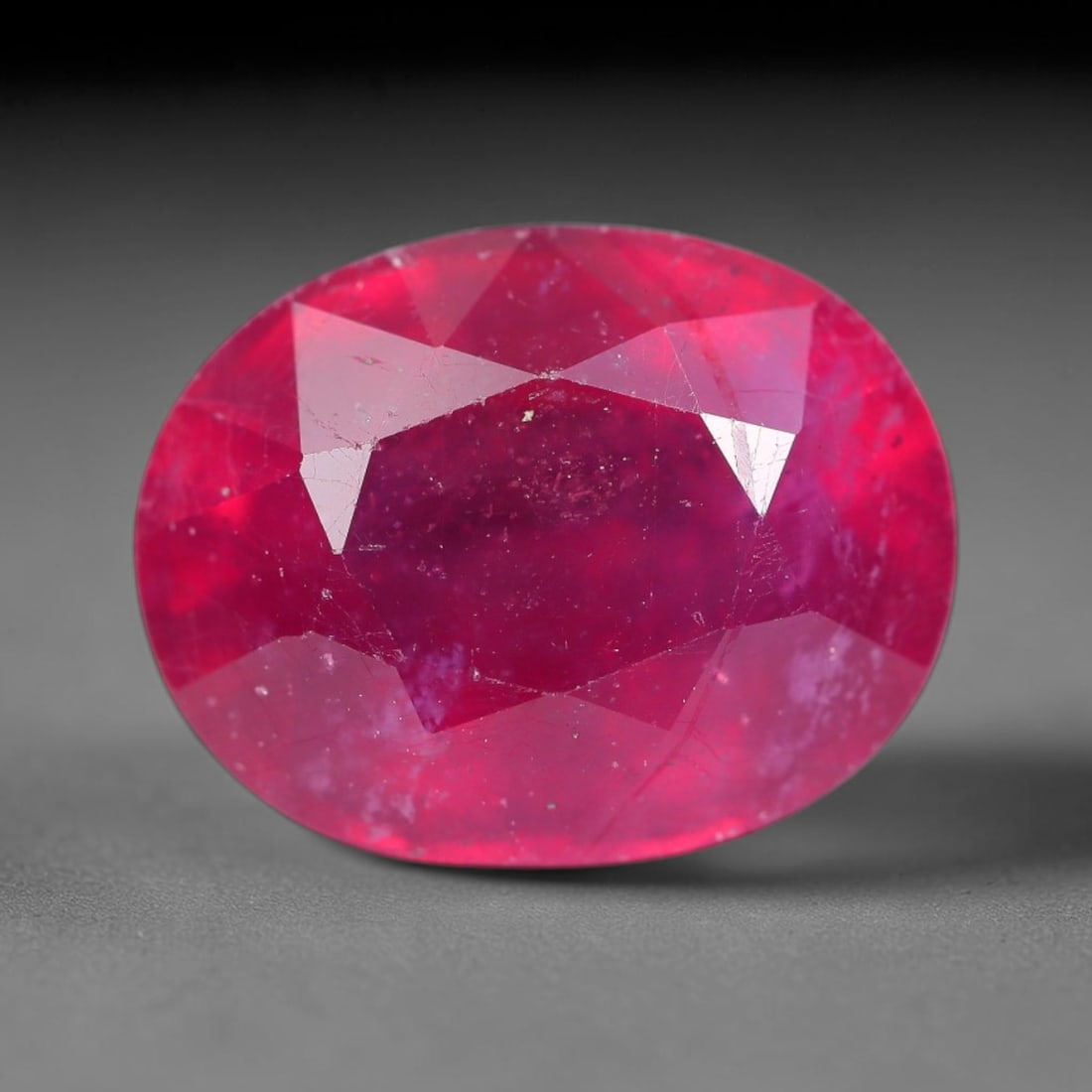 7.03 Carats Natural Mozambique Ruby Oval Faceted Loose Gemstone, 24SA: This natural Mozambique ruby is fashioned with standard oval brilliant faceting, displaying vivid saturated crimson-red hue accompanied by native fine mineral inclusions and subtle trace marks inheren