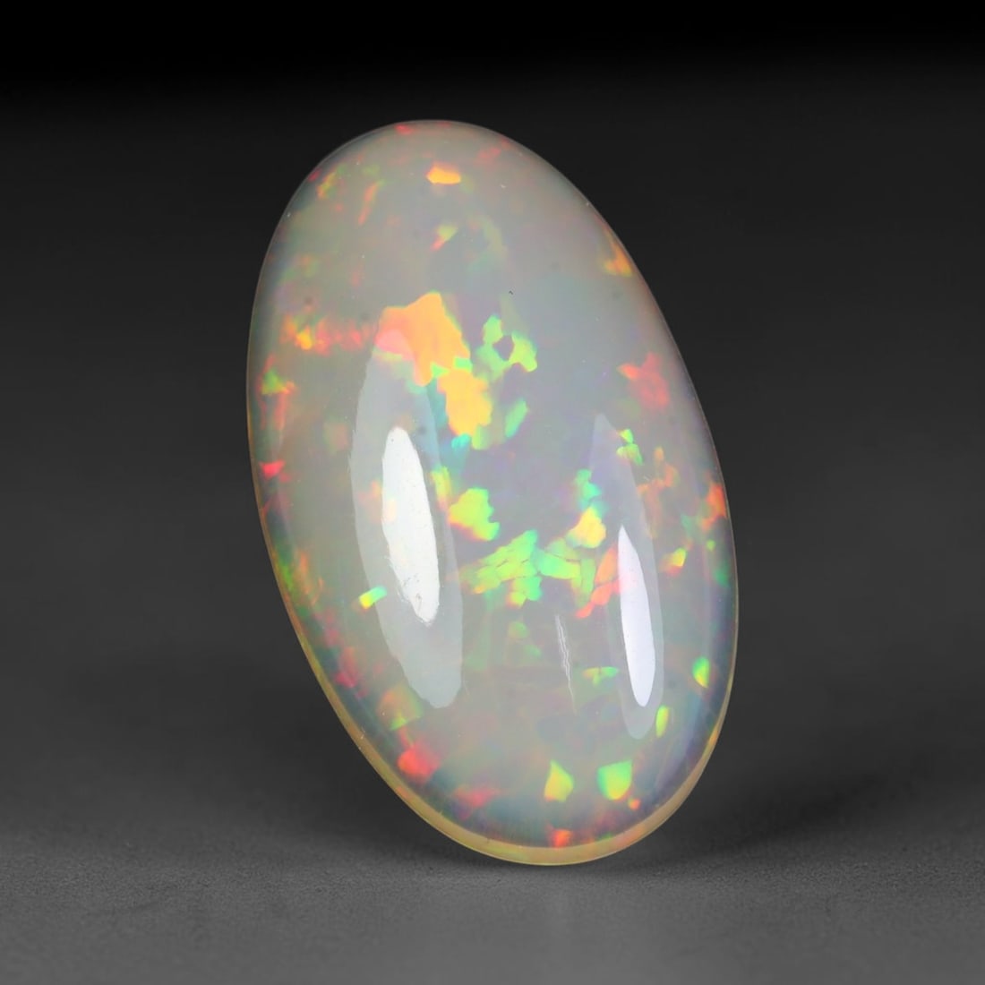 23.92ct Natural Multicolor Fire Ethiopian Welo Solid Opal Cabochon, 64TY: Formed from natural silica deposits within Ethiopian mineral veins, this solid opal cabochon features a smooth polished domed surface that highlights its natural light diffraction properties. Distinct