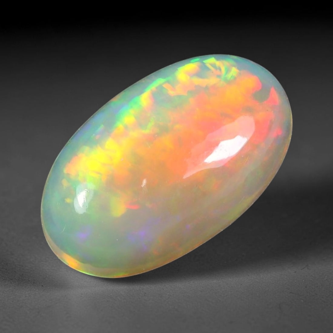 7.49ct Natural Multicolor Fire Ethiopian Welo Solid Opal Cabochon, 66TY: Formed from natural silica deposits within Ethiopian mineral veins, this solid opal cabochon features a smooth polished domed surface that highlights its natural light diffraction properties. Large fl