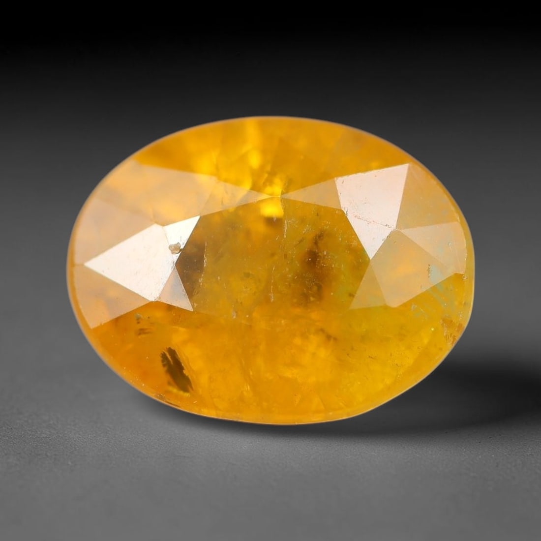 2.30 Carats Natural Yellow Sapphire Oval Faceted Loose Gemstone, 82TT: This natural yellow sapphire features a classic oval brilliant faceted cut, holding consistent warm golden-yellow color throughout the corundum crystal. Fine microscopic mineral specks and faint natur