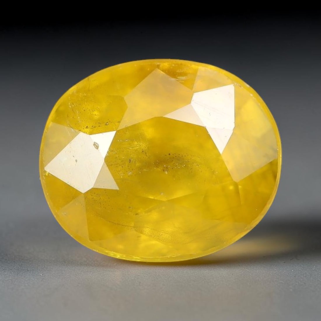 3.13 Carats Natural Yellow Sapphire Oval Faceted Loose Gemstone, 26TT: This natural yellow sapphire features a classic oval brilliant faceted cut, holding consistent warm golden-yellow color throughout the corundum crystal. Fine microscopic mineral specks and faint natur