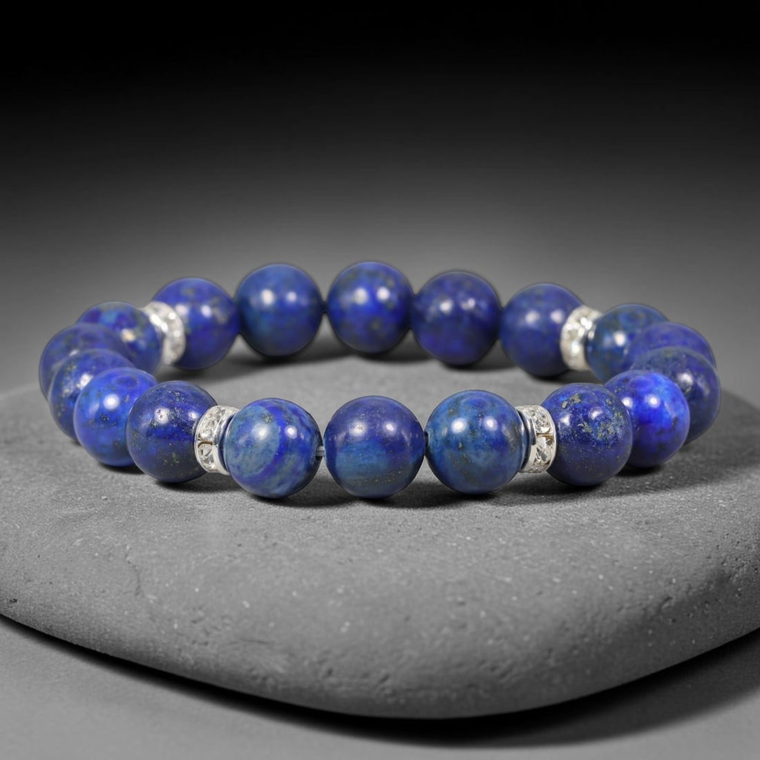 Lapis Lazuli Beaded Bracelet - Polished Gemstone Strand, 89TP: This hand-strung bracelet features uniform polished lapis lazuli round beads measuring 10.86mm, accented with decorative silver-toned spacer beads between select stones. The lapis displays characteris