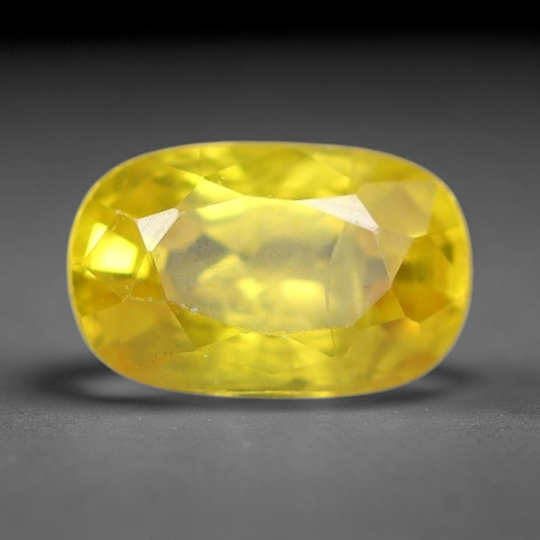 0.78 Carats Natural Yellow Sapphire Oval Faceted Loose Gemstone, 76TT: This natural yellow sapphire features a classic oval brilliant faceted cut, holding consistent warm golden-yellow color throughout the corundum crystal. Fine microscopic mineral specks and faint natur