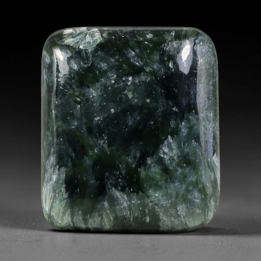 14.30 Carats Natural Deep Green Siberian Seraphinite Polished Cabochon, 35TZ: This is a fully natural polished seraphinite specimen sourced from Siberian deposits, displaying distinct feathery fibrous inclusions that create beautiful flowing chatoyant patterns across its smooth