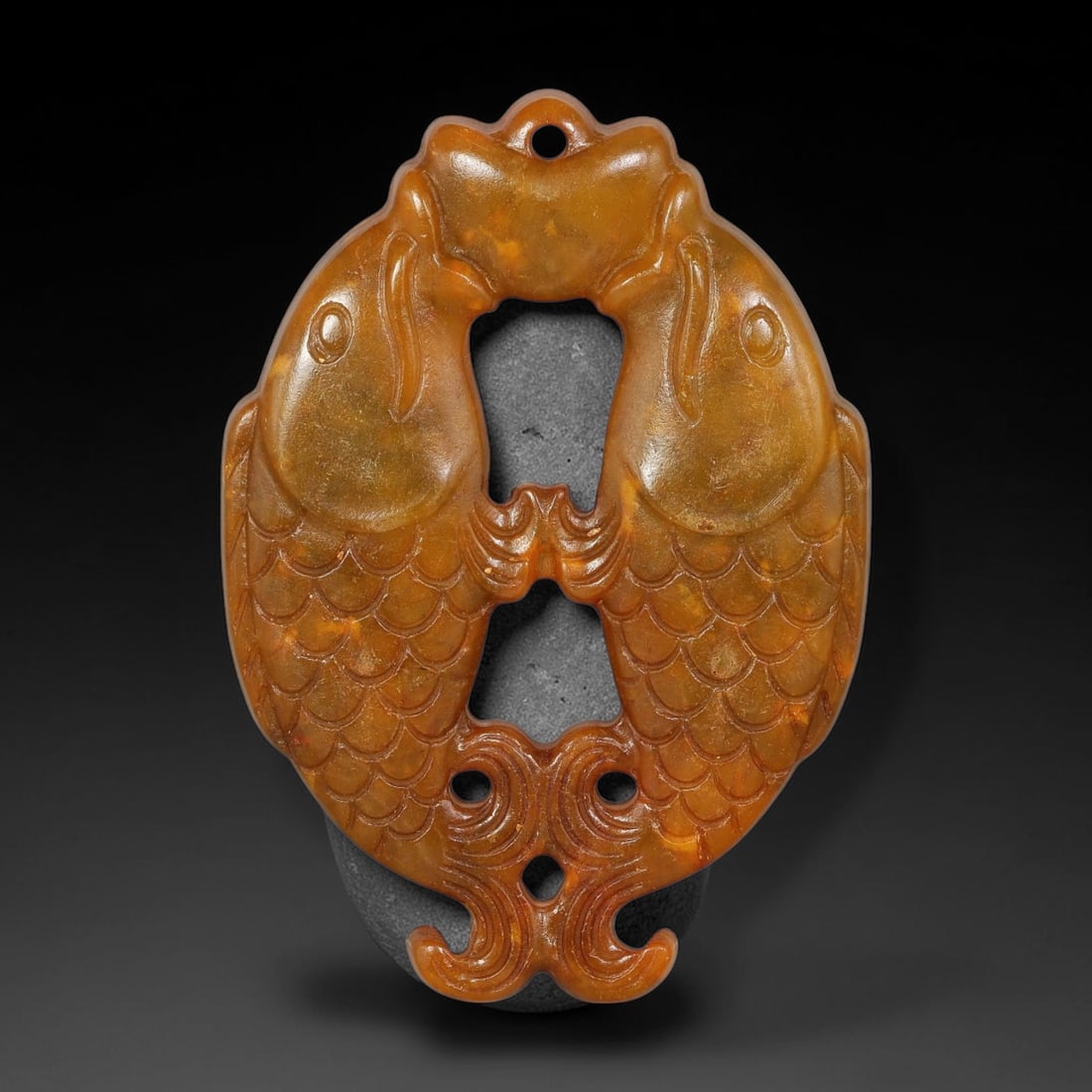 A Chinese Open-Work Carved Yellow-Brown Jade Stone Twin-Fish Pendant, 93YF: Ornate open-work jade pendant featuring symmetric twin-fish composition with finely rendered incised scale details. A suspension hole is placed at the top for cord threading. Decorative scroll-style c
