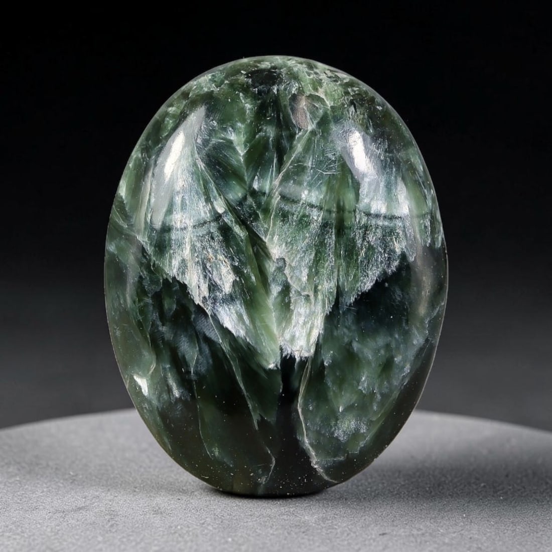 15.81 Carats Natural Deep Green Siberian Seraphinite Polished Cabochon, 53TZ: This is a fully natural polished seraphinite specimen sourced from Siberian deposits, displaying distinct feathery fibrous inclusions that create beautiful flowing chatoyant patterns across its smooth