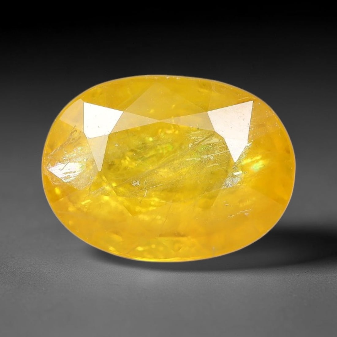 2.14 Carats Natural Yellow Sapphire Oval Faceted Loose Gemstone, 16TT: This natural yellow sapphire features a classic oval brilliant faceted cut, holding consistent warm golden-yellow color throughout the corundum crystal. Fine microscopic mineral specks and faint natur