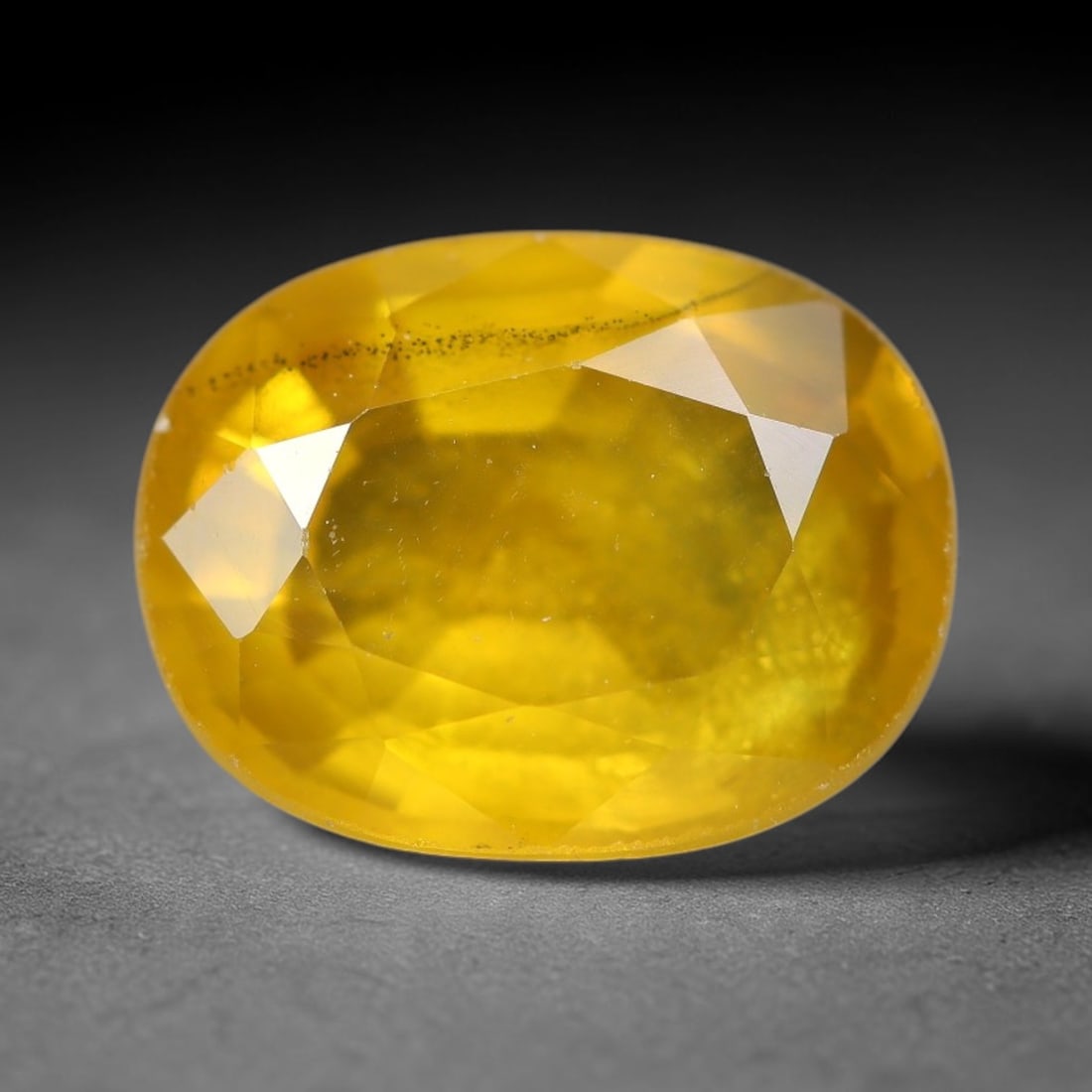2.46 Carats Natural Yellow Sapphire Oval Faceted Loose Gemstone, 80TT: This natural yellow sapphire features a classic oval brilliant faceted cut, holding consistent warm golden-yellow color throughout the corundum crystal. Fine microscopic mineral specks and faint natur