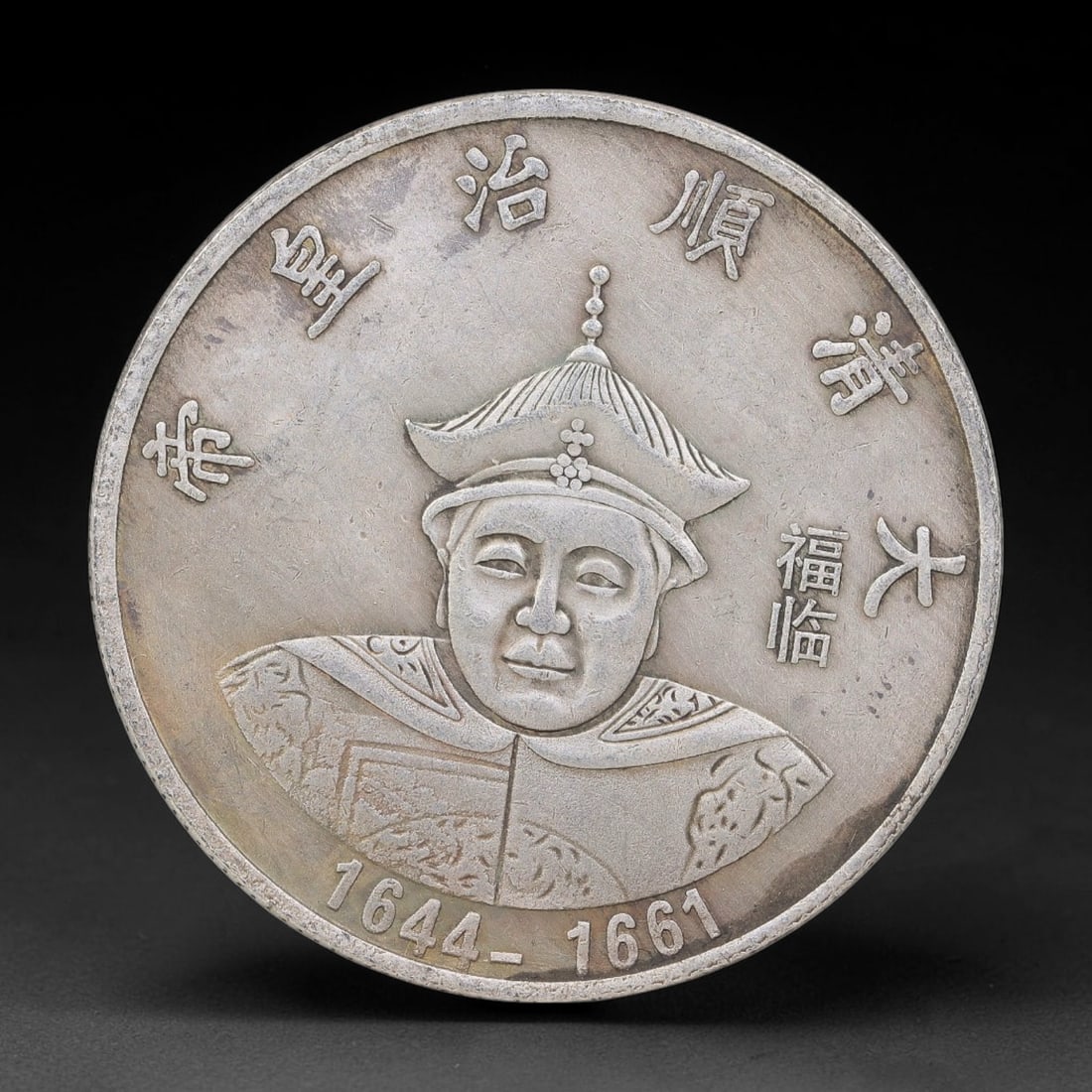 A Chinese Metal Commemorative Coin - Shunzhi Emperor Dragon Medallion, 59ZQ: Cast base-metal medallion with double-sided relief ornamentation. The obverse shows a bust portrait of the Shunzhi Emperor in traditional Qing imperial ceremonial headdress and robes, surrounded by mo