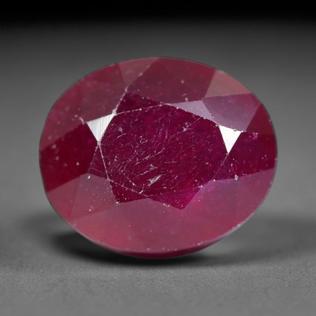 6.40 Carats Natural Madagascar Ruby Oval Faceted Loose Gemstone, 4SA: This sizable natural Madagascar ruby is cut into an oval brilliant faceted form, showcasing rich saturated crimson red hue characteristic of Malagasy corundum. Extensive natural internal silk veining,