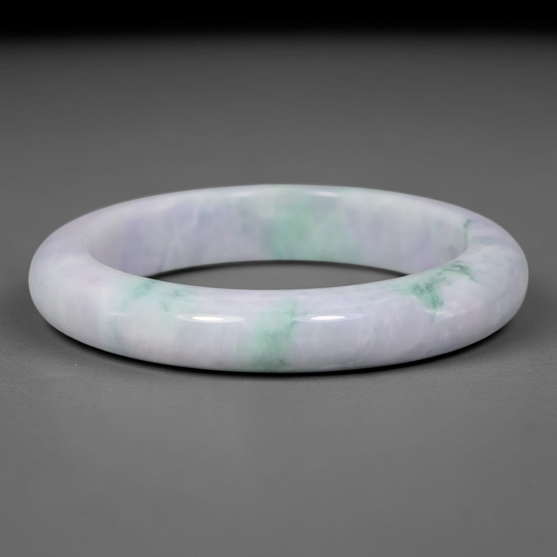 Natural Burmese Type A Lavender Floating Green Jadeite Jade Bangle Bracelet, 30TD: This rounded band bangle is crafted from natural Burmese Type A jadeite. The stone features a soft pale lavender base with flowing streaks of floating green weaving across the surface. The surface has