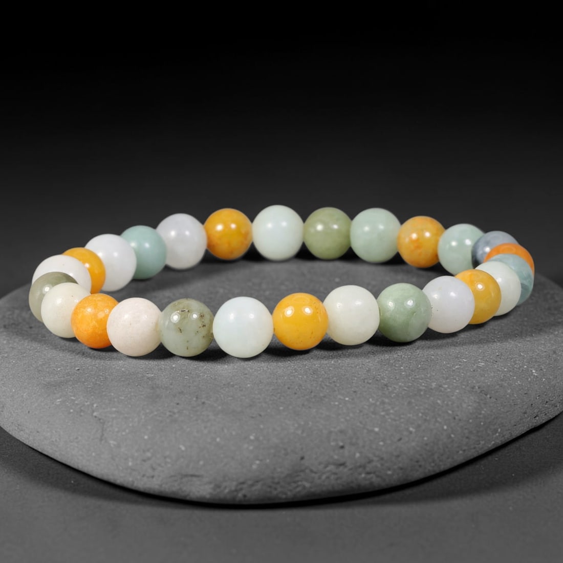 Natural Burmese Type A Multi-Colored Jadeite Jade Bracelet, 60TK: Hand-strung bracelet with polished round natural Burmese Type A jadeite beads measuring 7.8mm. The beads combine milky white, soft pale celadon, earthy green and warm golden-orange tones, featuring na