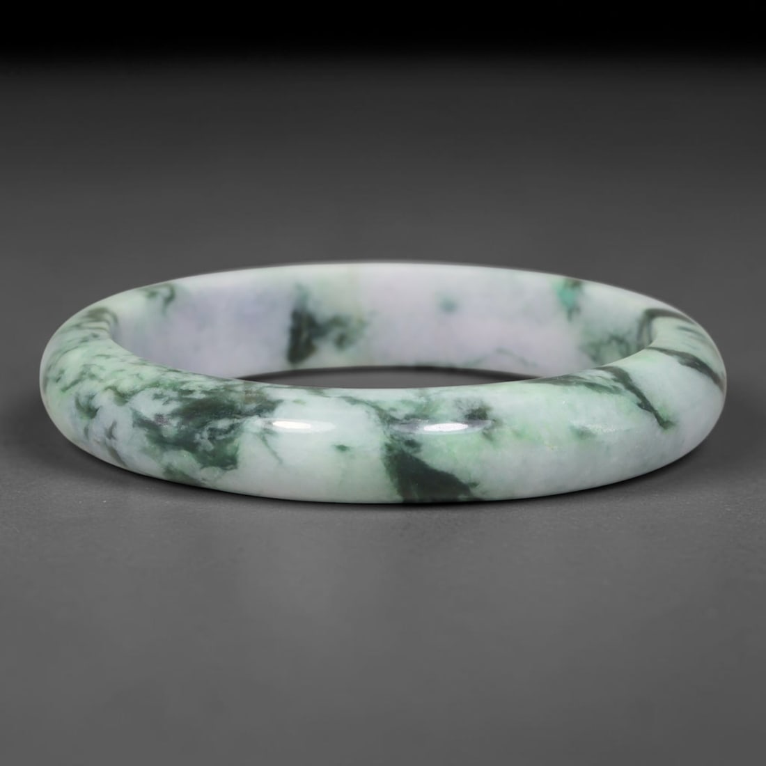 Natural Burmese Type A Streaky Floating Green Jadeite Jade Bangle Bracelet, 37TD: This rounded band bangle is crafted from natural Burmese Type A jadeite. The stone features a pale milky white base with bold streaky deep green inclusions flowing across the surface, creating natural