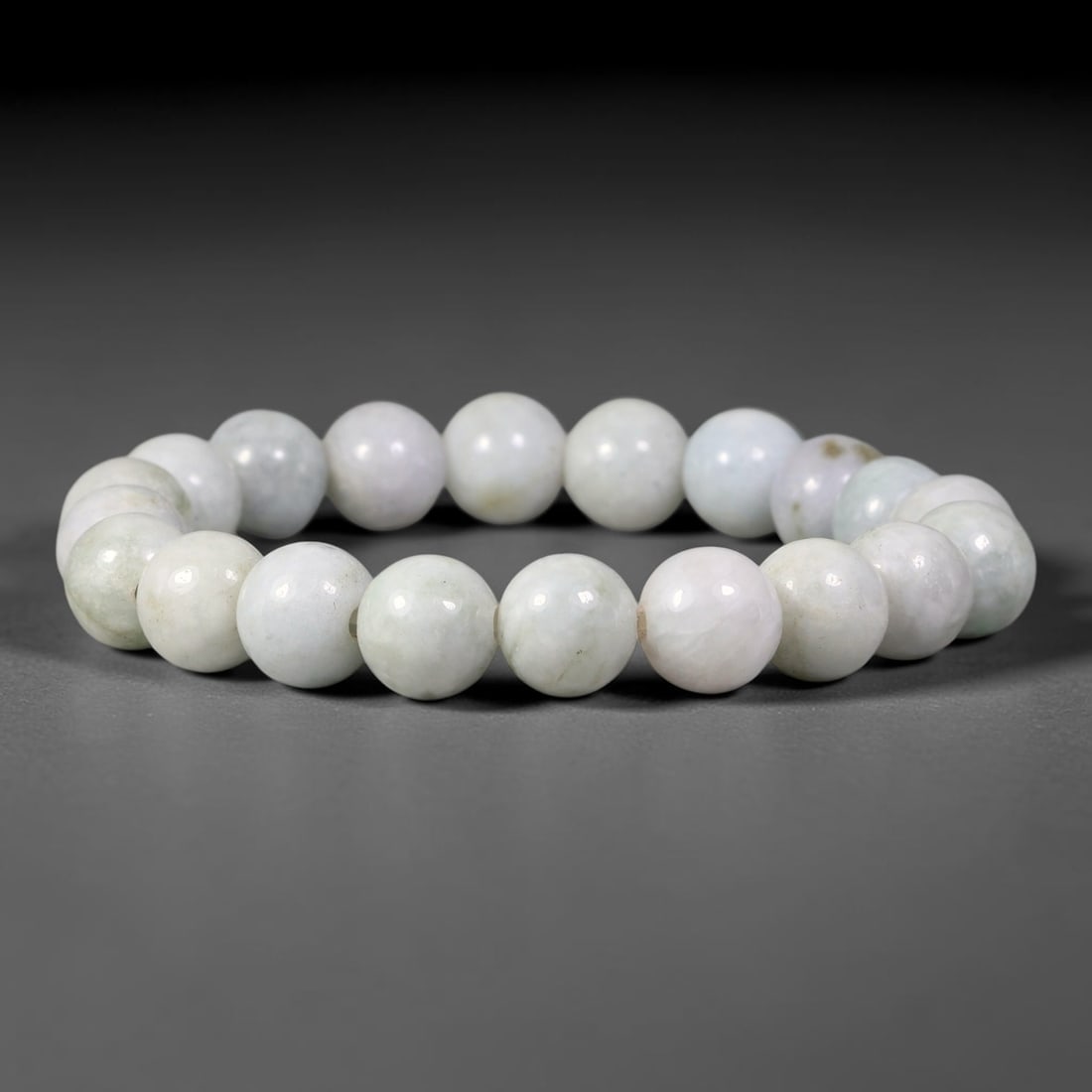 Natural Burmese Type A Pale Milky White Jadeite Jade Bracelet, 74TK: Hand-strung bracelet crafted from polished round natural Burmese Type A jadeite beads measuring 10.6mm. The beads feature soft milky white tones with faint pale lavender hints and subtle natural inclu