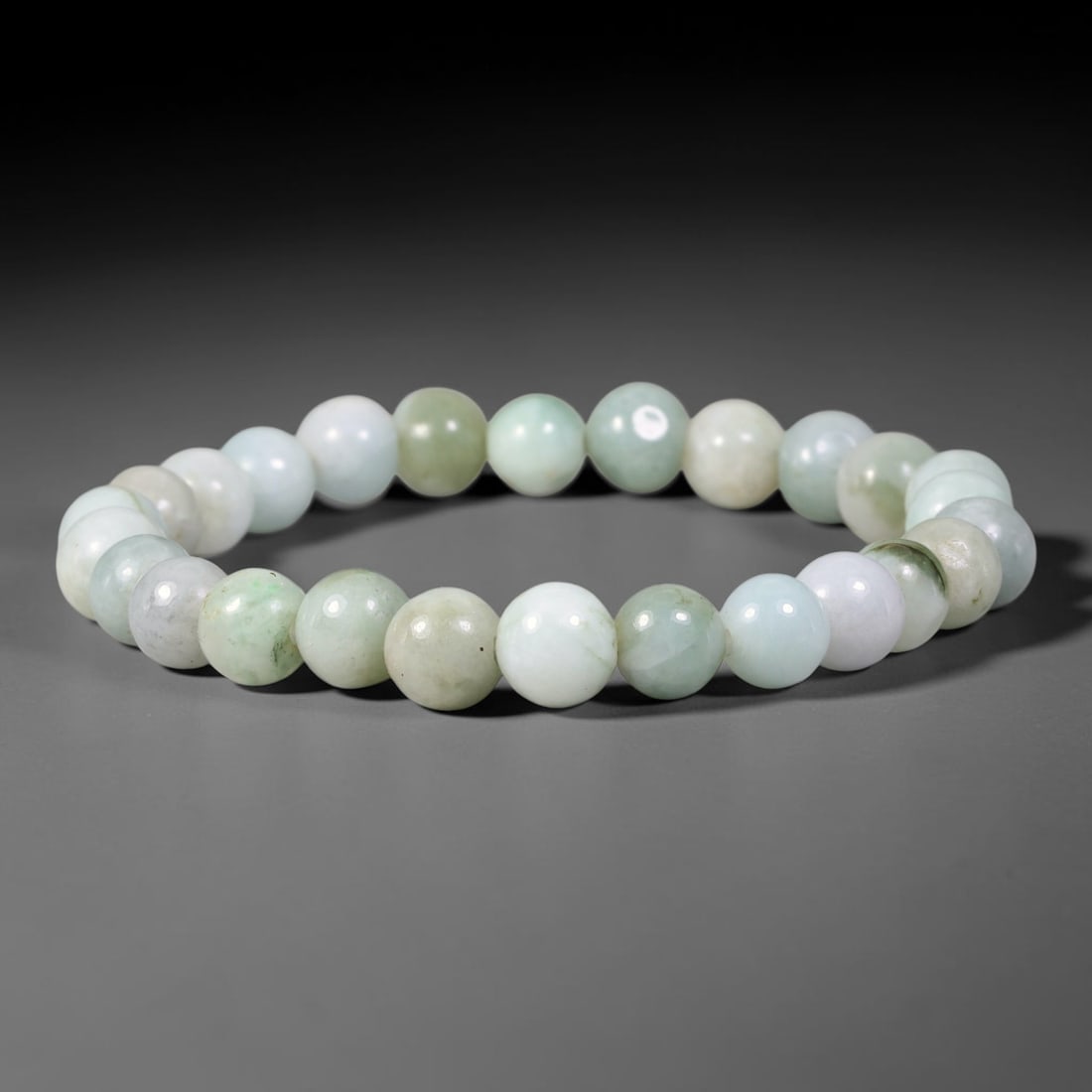 Natural Burmese Type A Variegated Pale Celadon Jadeite Jade Bracelet, 73TK: Hand-strung bracelet with polished round natural Burmese Type A jadeite beads measuring 8.8mm. The beads blend milky white, soft pale celadon and subtle mossy green mottling with natural faint inclusi