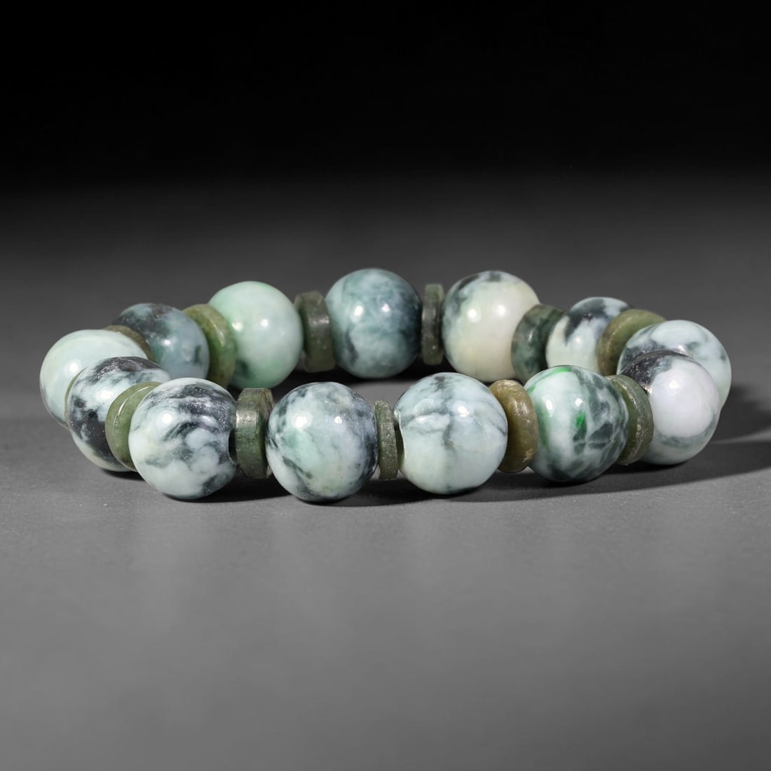 Natural Burmese Type A Floating Dark Green Mottled Jadeite Jade Bracelet, 47TK: Hand-strung bracelet of polished round natural Burmese Type A jadeite beads measuring 13.8mm. The beads feature a milky white base with dramatic swirling dark green and blackish floating mottling. Thi