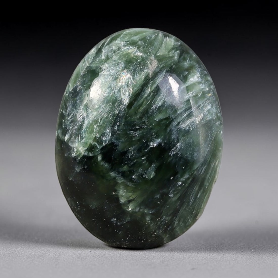 11.67 Carats Natural Deep Green Siberian Seraphinite Polished Cabochon, 49TZ: This is a fully natural polished seraphinite specimen sourced from Siberian deposits, displaying distinct feathery fibrous inclusions that create beautiful flowing chatoyant patterns across its smooth