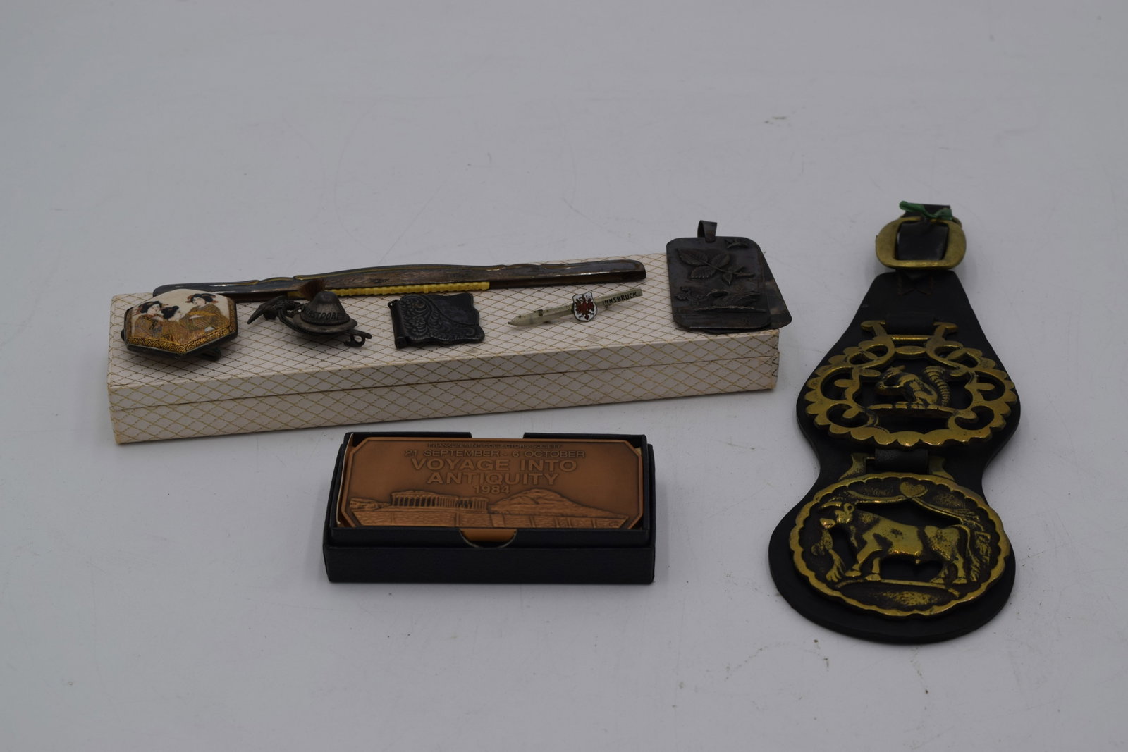 Mix of Metal Items Pins Medallions: brass and leather horse harness with medallions. Franklin Mint 1984 collectors ingot. Geisha Satsuma pin, Innsbruck ski pin, Oberstdorf mountain pun, swan pendant, floral buckle, hair comb overlay. (d