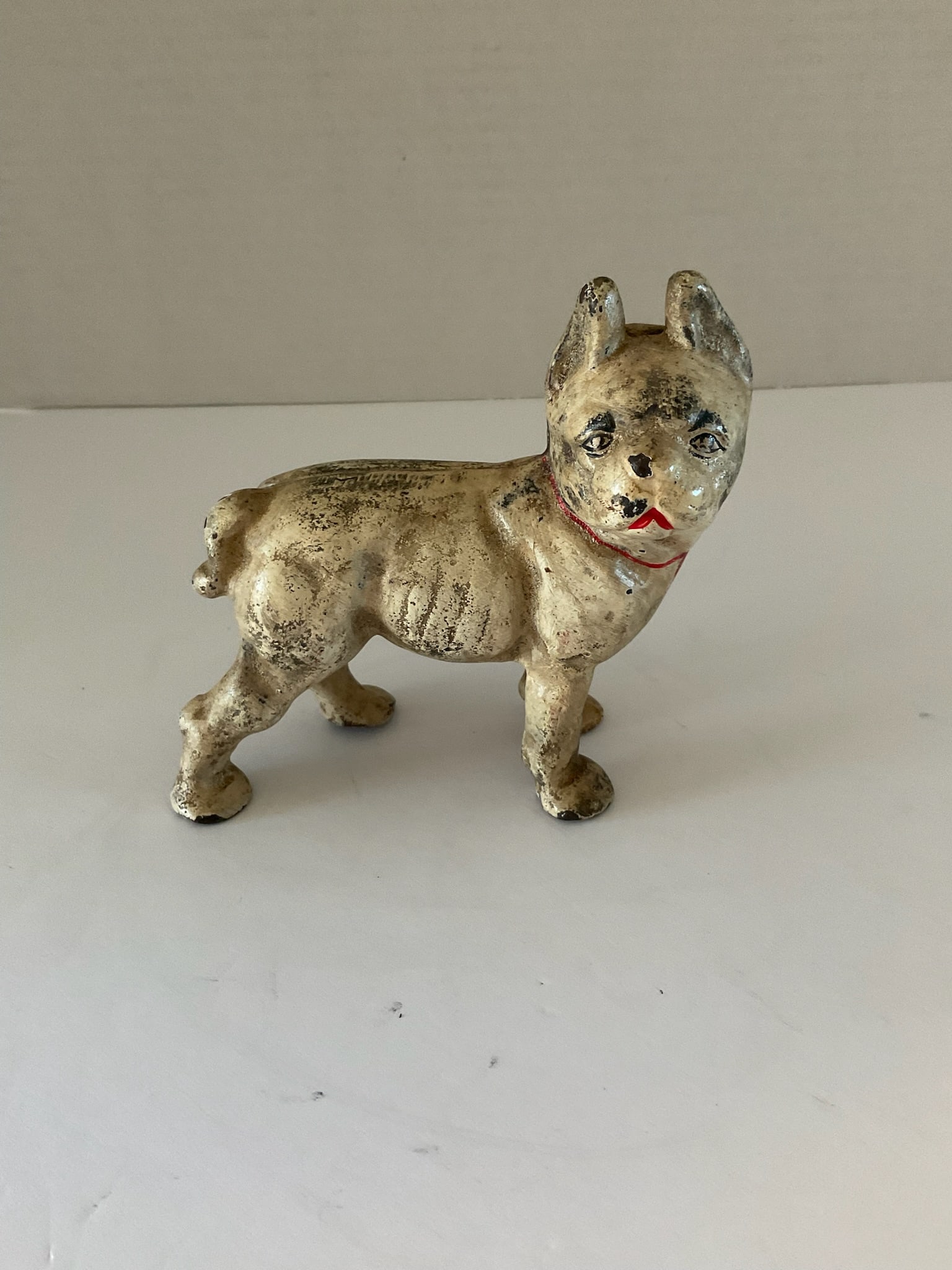 Small Cast Iron Bulldog Paperweight: Small antique cast iron French bulldog paperweight. This piece is held together with a flat head screw. It appears to have some of the original paint. It measures approximately 4.5 inches high and 5 i