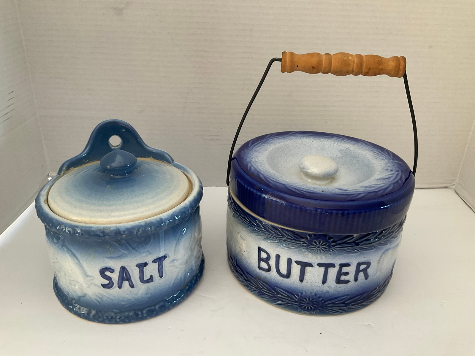 Antique Salt Crock and Matching Butter Crock: A set of blue and white antique crocks. One is for butter and one for salt. The salt has some odd residue to the interior. Butter crock is 6"h x 7 x 7". Both show wear, please see photos.