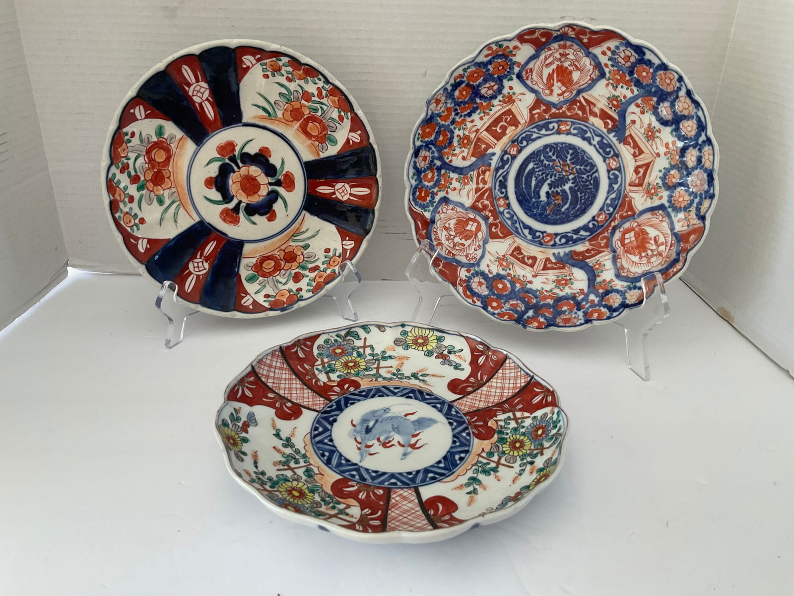 Trio of Antique Imari Plates: A trio of antique Imari plates. Each is approximately 9" in diameter. One has the image of a stylized animal, one is a basket of flowers and the last is a single flower. Good antique condition with mi