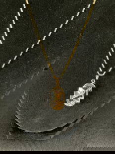Vintage Asian Inspired 18K Yellow Gold Pendant and Chain: A vintage 18K yellow gold Asian inspired pendant with a 19" chain. The pendant is an oval shape with a bird in flight set atop a smoky crystal - the pendant has unusual markings that we have tried