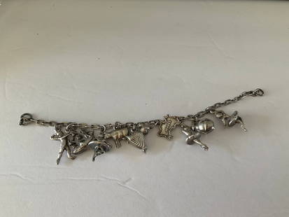 Vintage Sterling Charm Bracelet with Nine Charms: A vintage Sterling charm bracelet with nine charms. This piece has dancers, jug, New Jersey and more. 6" in length and 29.6 grams.