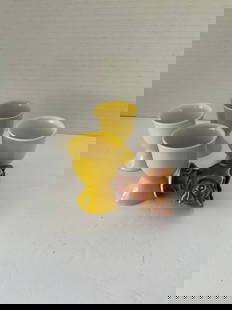 Five Mid Century Egg Cups: A collection of five ceramic egg cups, two white, two yellow and a chicken themed. Each is approximately 4"h x 2" in diameter.