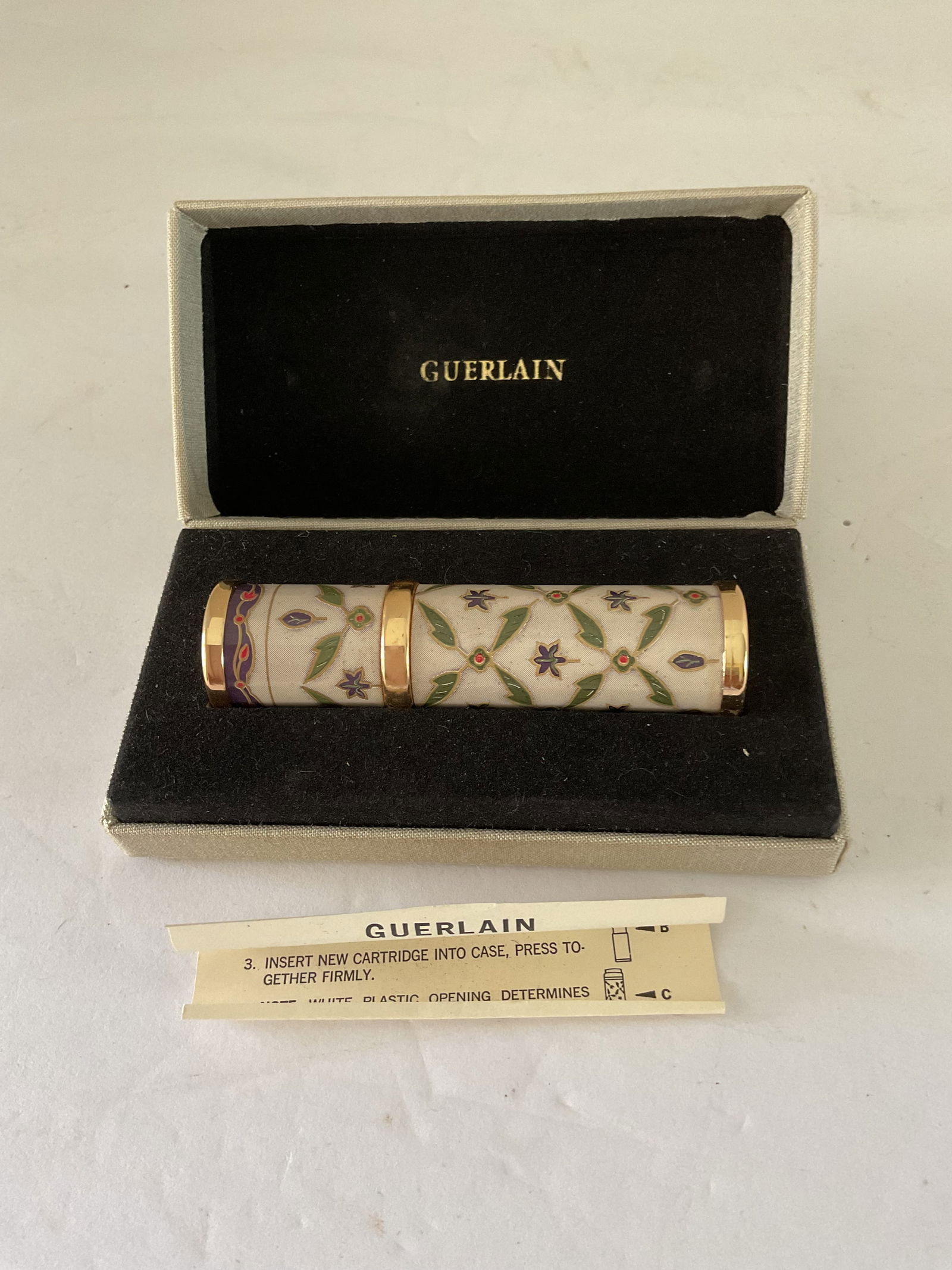 Guerlain Purse Perfume Atomizer IOB: A Guerlain floral purse perfume atomizer. This piece comes in the original box with instructions. The atomizer is 3" in length. Remnants of perfume remain.