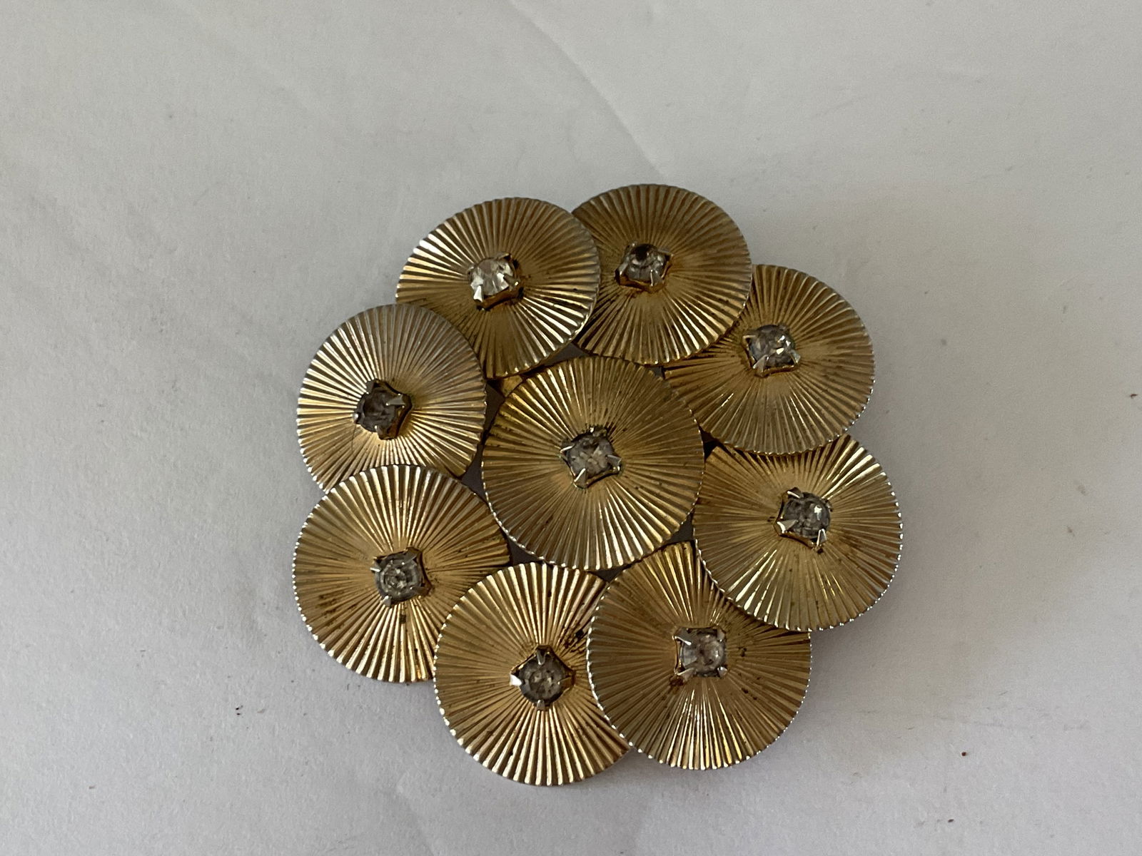 Mid Century Classic Coro Brooch.: This piece consists of nine fanned discs, each with a square set crystal. Signed Coro to the verso. 2" in diameter.