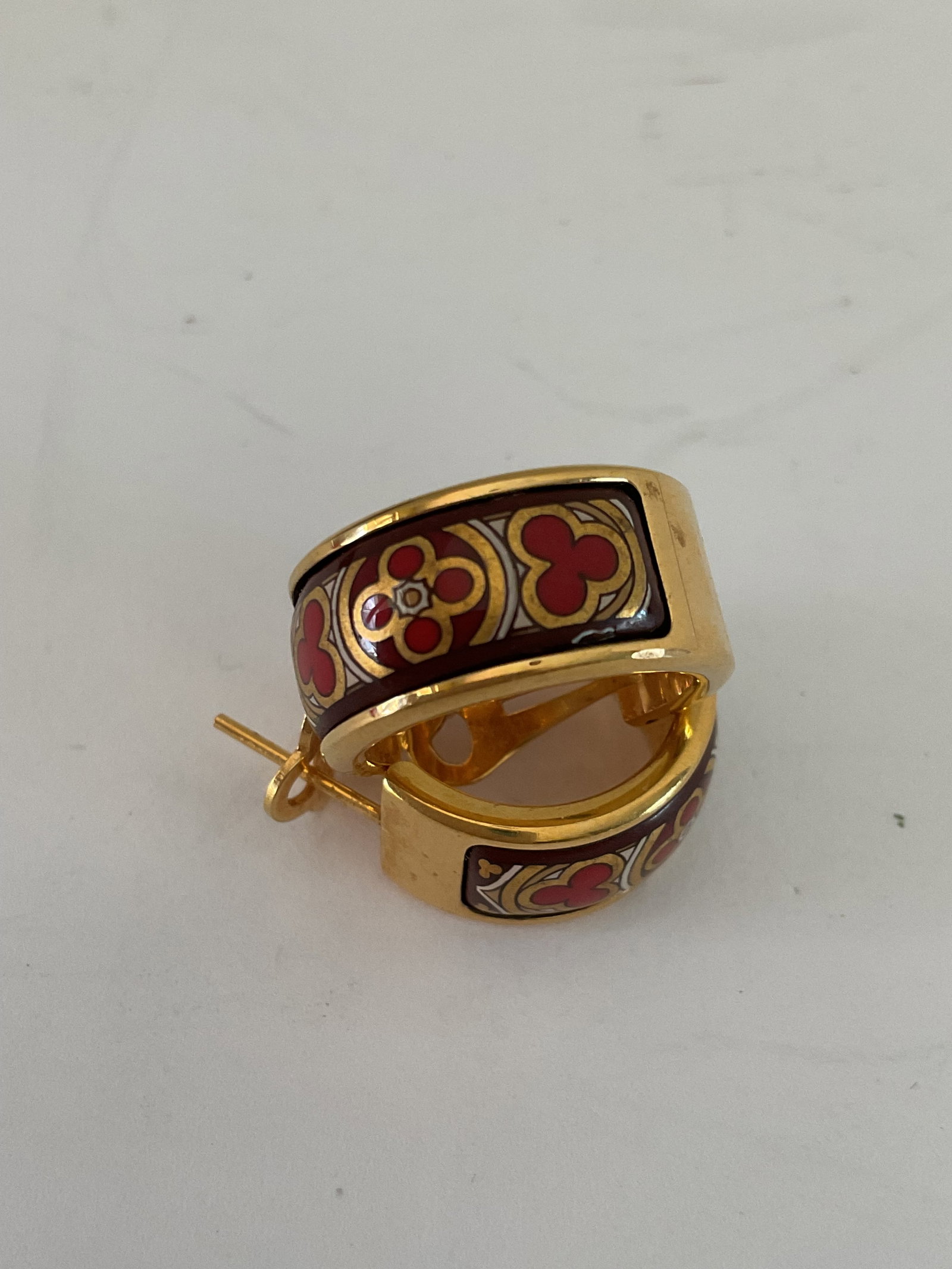 Michalea Frey 24k gold plated Enameled Earrings: A pair of Michaela Frey huggie style 24k gold plated earrings. The earrings have a gold, red and black design. .69" in diameter.
