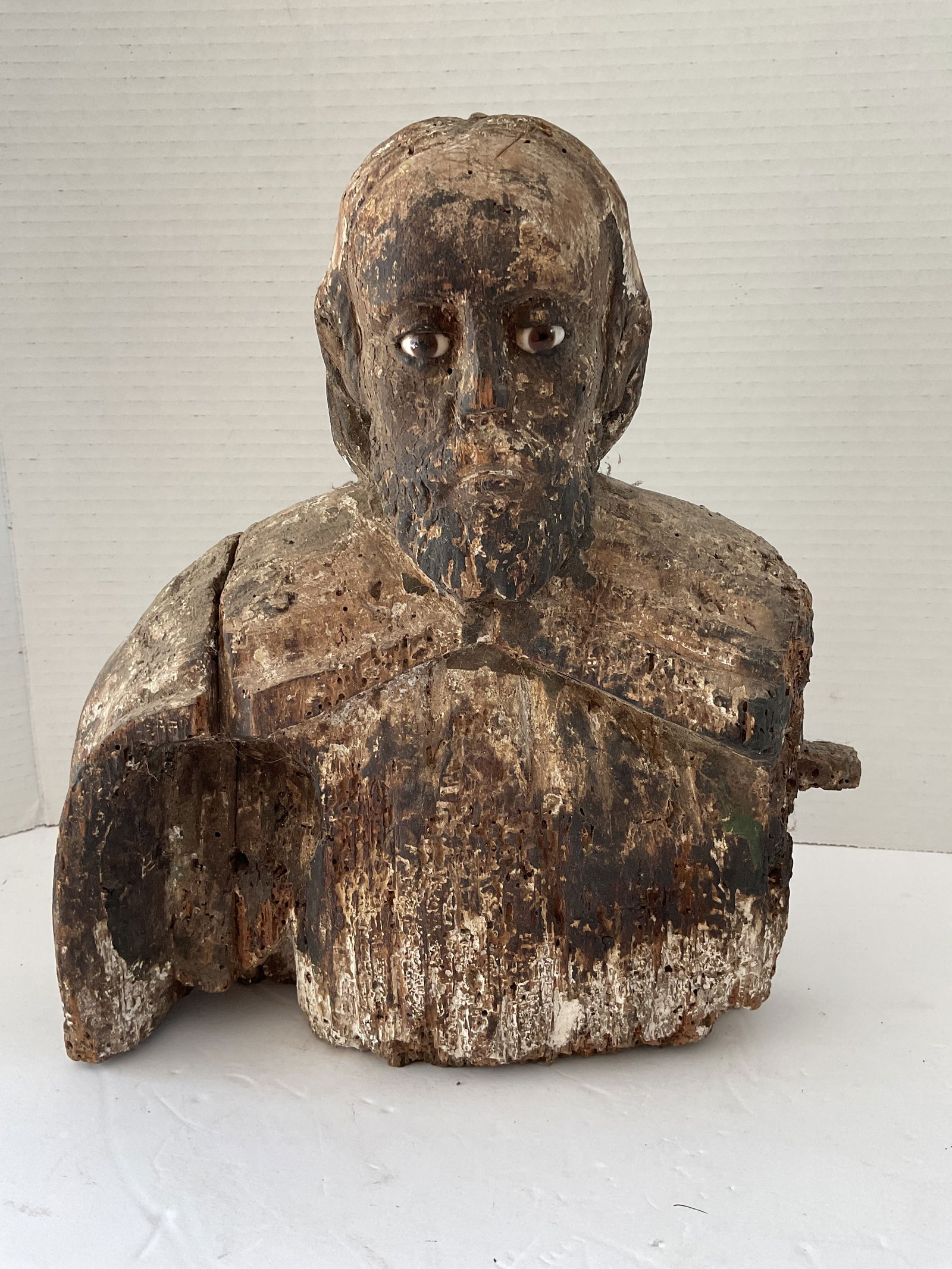 Spanish Colonial 18th Century Carved Wood Apostle Bust: A wood bust of a Spanish Colonial Apostle. This wooden carved piece is from the 18th century. It has the upper torso with head fitted with glass eyes. it measures approximately 12 x 10 x 3 inches. Ple