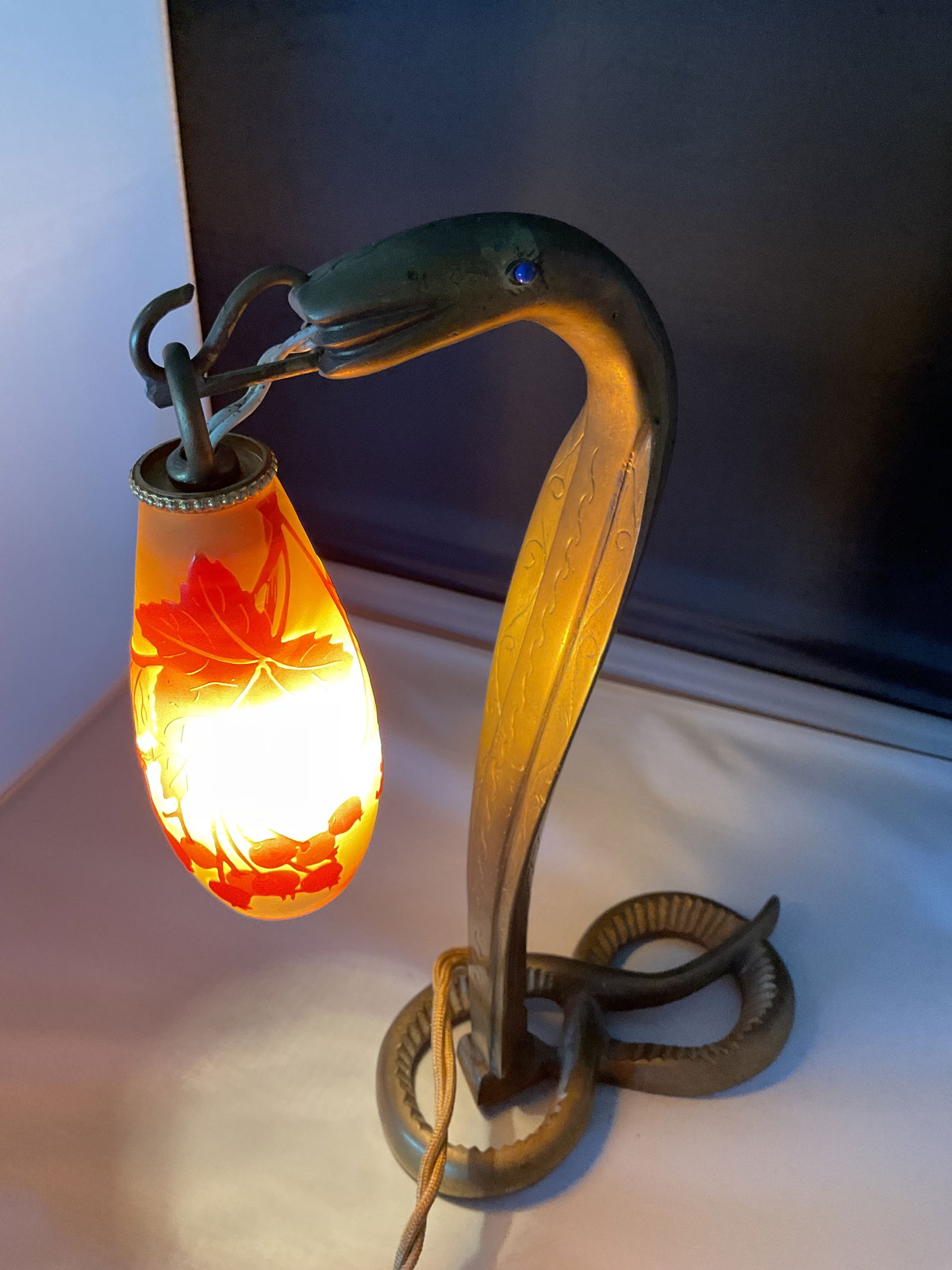 Vintage E. Galle Serpent Lamp Circa 1924: An E. Galle serpent lamp with bronze base and lapis lazuli eyes. 10.5" in height, it has a cameo shade in yellow and orange depicting berries and foliage. Some wear to the finish and a bit of fraying