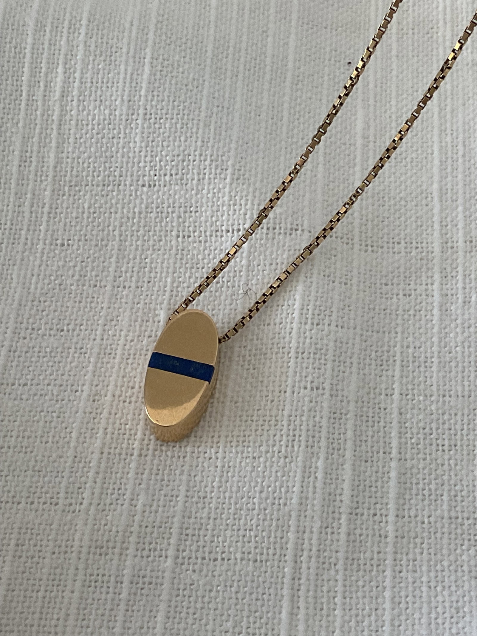 14K Yellow Gold Box Chain with Attached Pendant Lapis Accent: A 14K stamped yellow gold pendant necklace. It has an attached oval pendant with a thin strip of lapis. It has a 16" box chain, weight is 7.3 grams