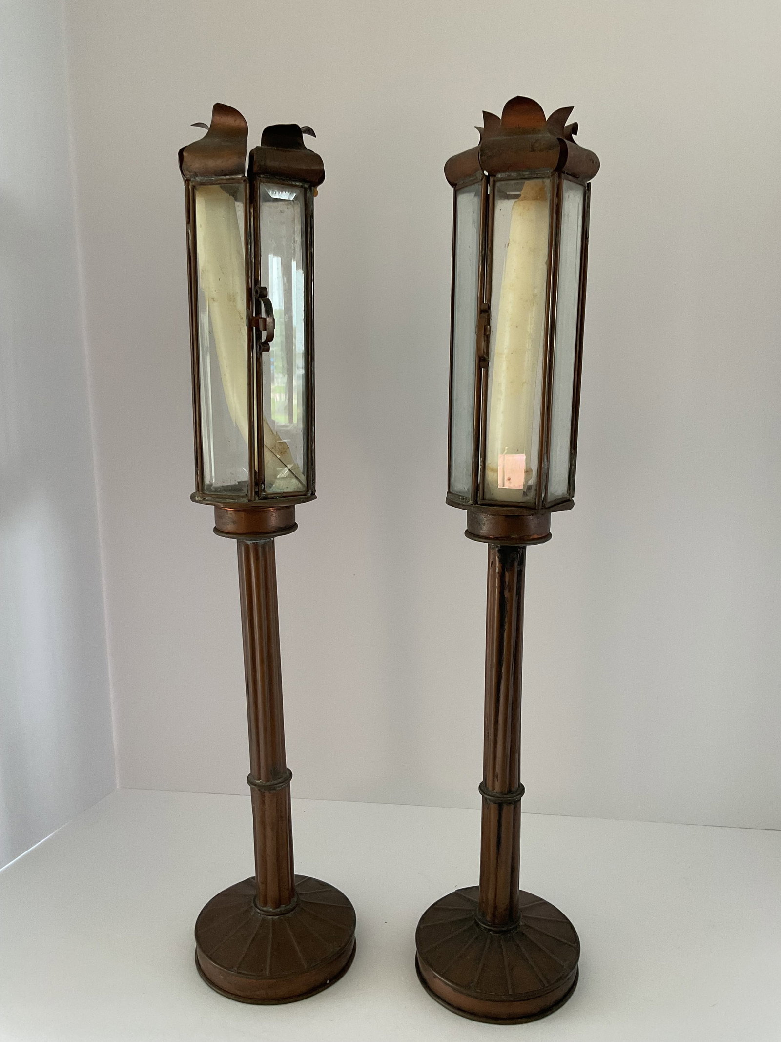 Pair of Unusual Copper Candleholders: A pair of mid century copper candleholders. Each holds a tall taper, a door opens at the top to remove or insert the candle. These appear to be from the 1950's to 1970's. Good used condition. Each is 