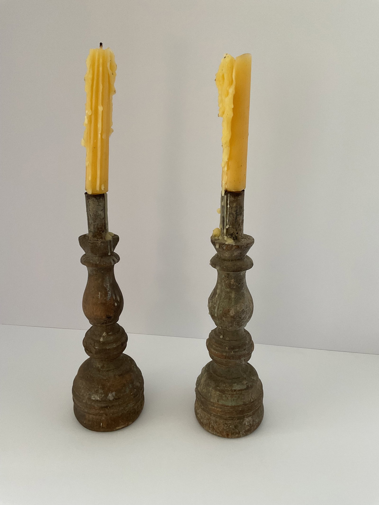 New Mexican 18th Century Spanish Colonial Turned Candleholders: A pair of 18th century turned candleholders from New Mexico. These are from an old Taos collection. Each measures 10" in height and 3" in diameter. Old drippy candles included