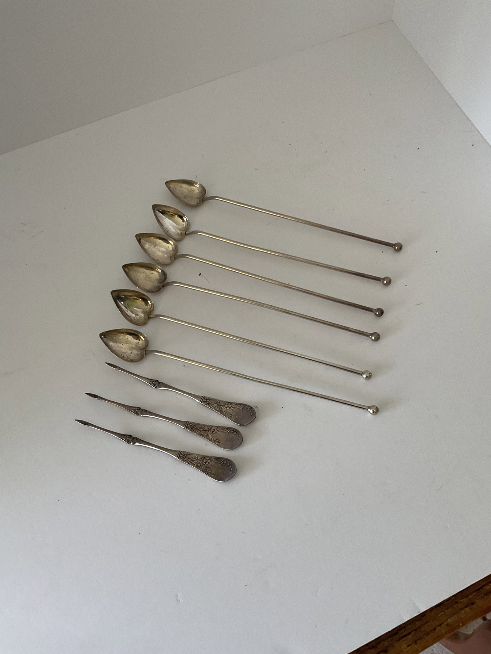Six Antique Sterling Iced Tea Spoons and Four Sterlling Nut Picks: A set of six stamped sterling Iced tea spoons, bowls are in the shape of a heart. Also included are four antique sterling nut picks. the weight is 117.6 grams.