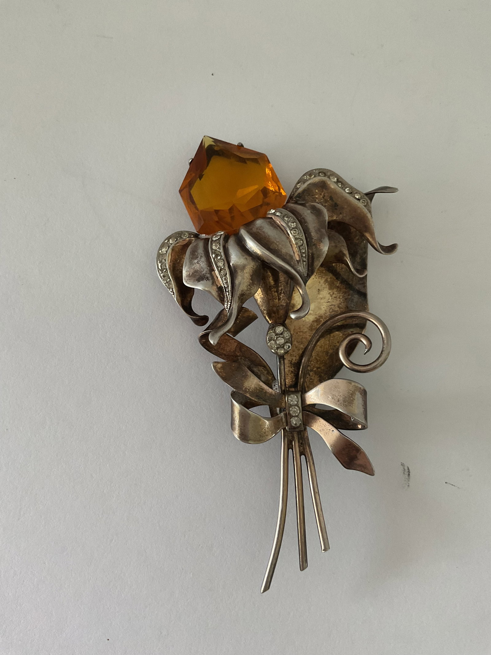 Huge Sterling Silver Mid Century Designer Brooch: A sterling silver (stamped) brooch form the mid 40's to 50's. Believed to be from truart. It is in the shape of a calla lily tied with a bow and accented with crystals and a large faux amber gem. It m