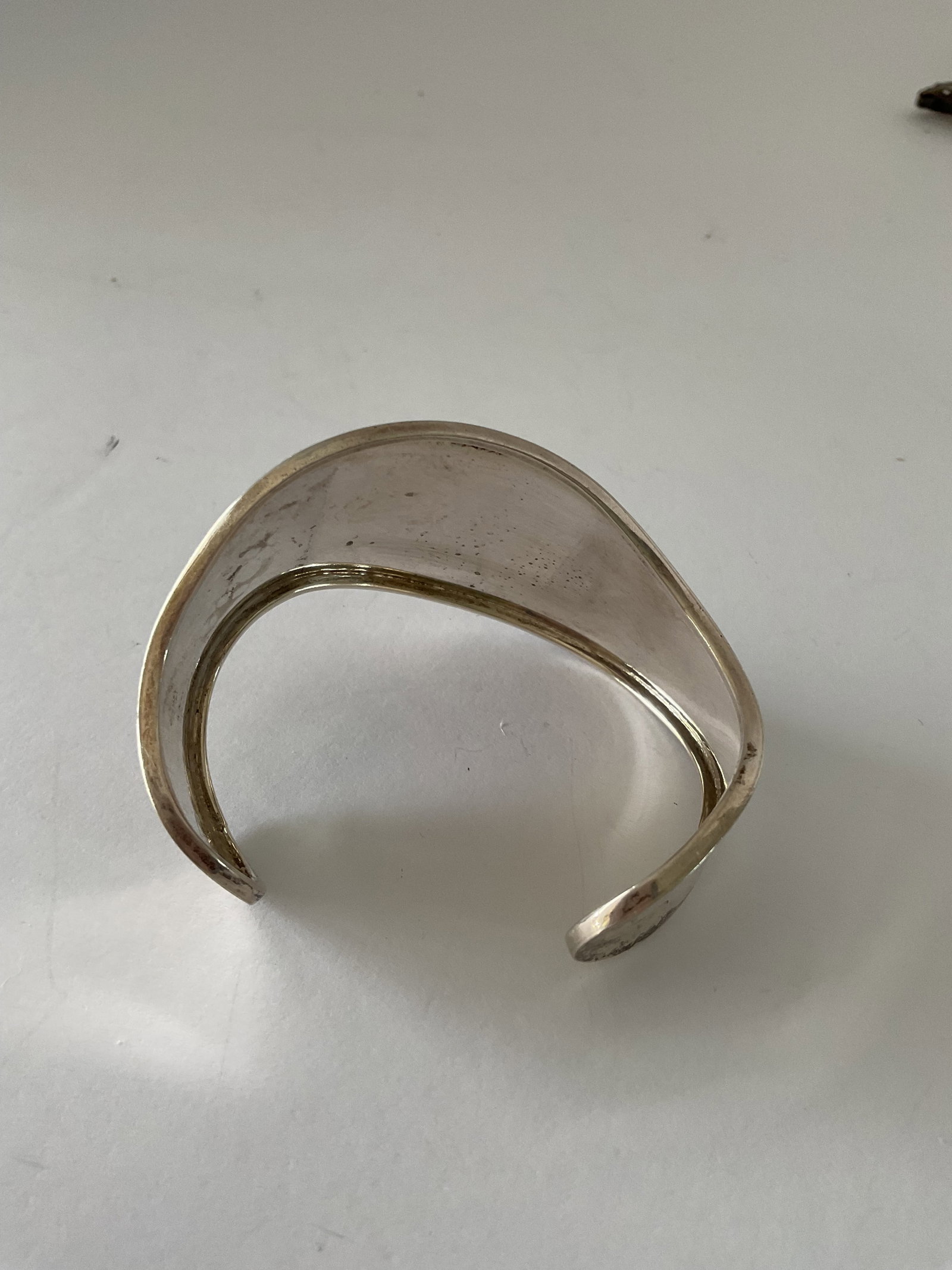 Mexican Sterling Silver Cuff Bracelet: A Mexican cuff bracelet in sterling silver, signed to the edge. It has a curved design, weight is 21.9 grams. 2.5"wide and 1.5" at its widest point.