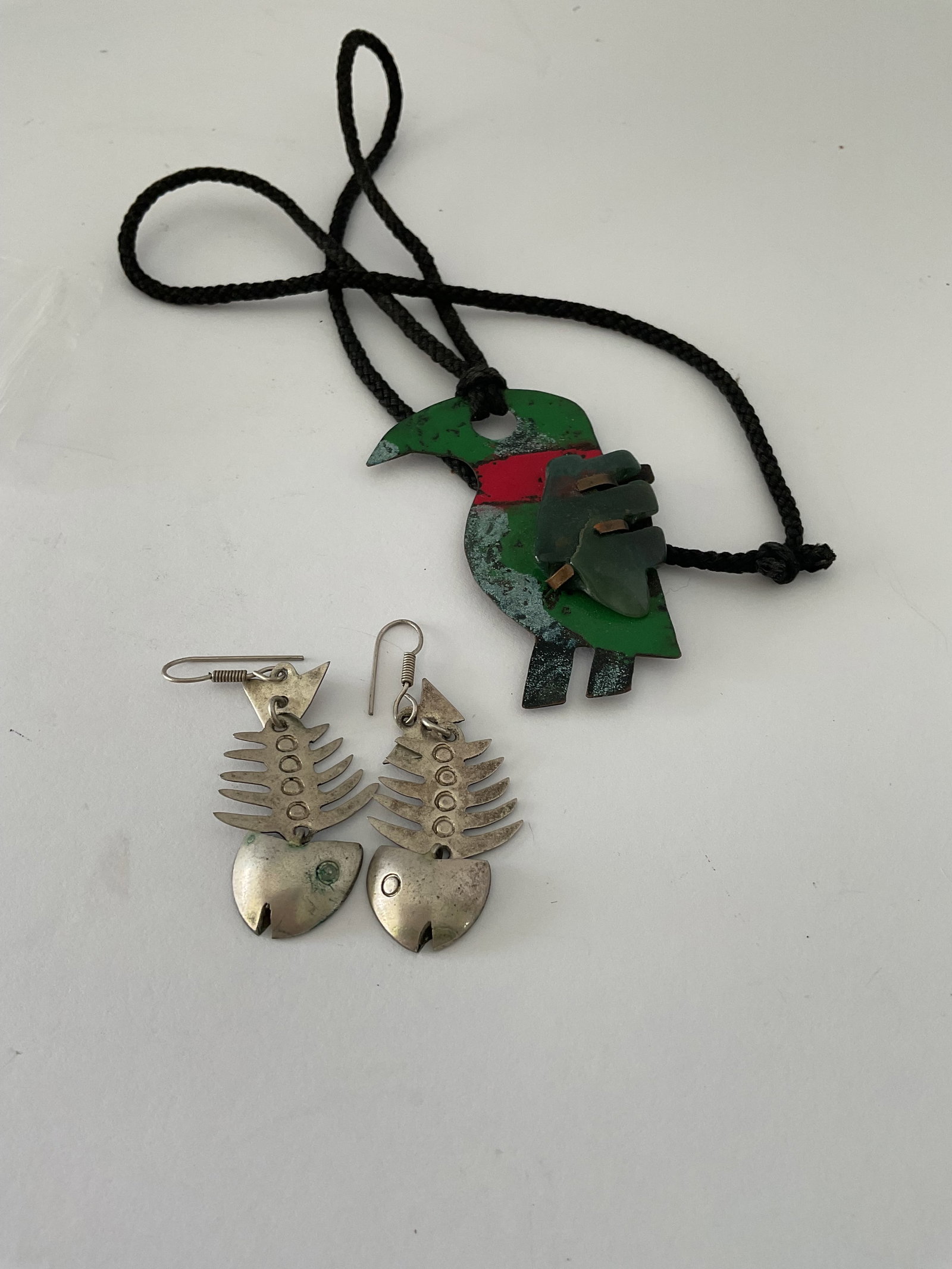 Fish Bone Earrings and Folk Art necklace: A pair of vintage Mexican fishbone earrings (sterling?) and a vintage folk art enamel Toucan pendant with a stone fetish on a black cord.