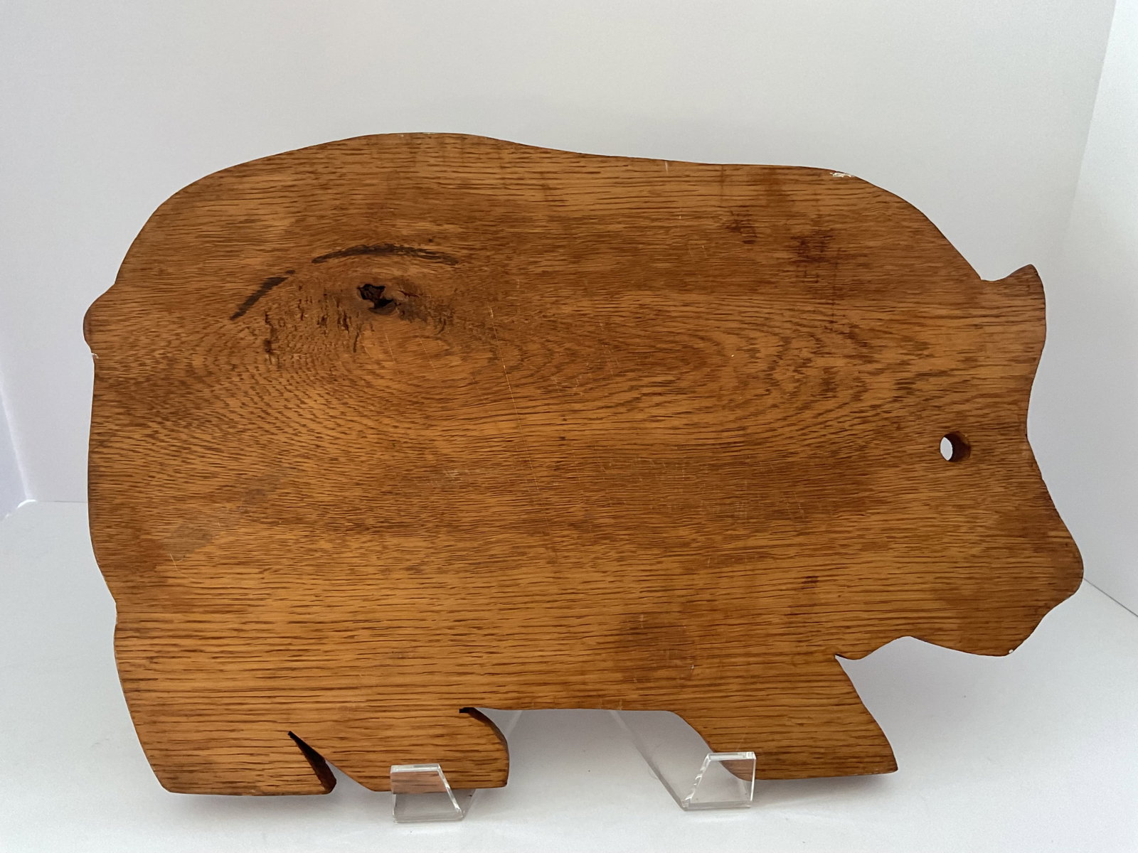 Vintage Wooden Cutting Board Pig Shape: A vintage wooden cutting board. This board has a pig shape and measures 16 x 10 x .5”. Please note the knot in the wood.