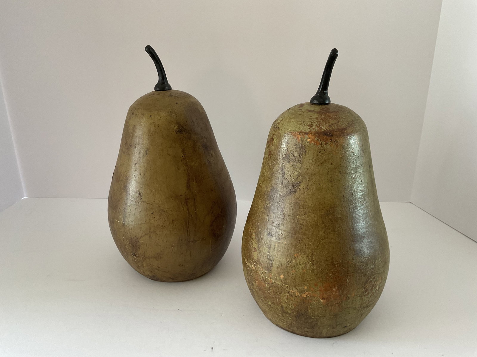 Pair of Ceramic Pears: A pair of ceramic decorative pears. The pieces have a rustic green finish, felt bottoms and hollow interior. Each is Approximately 10”h x 6” in diameter.
