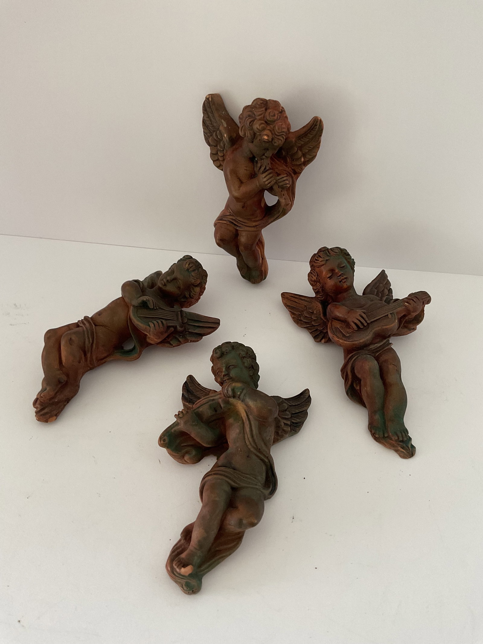 Four Vintage Wooden Cherubs: Four vintage wooden music themed cherubs. Each has a loop for hanging, and measures 5” x 4” at the wings.