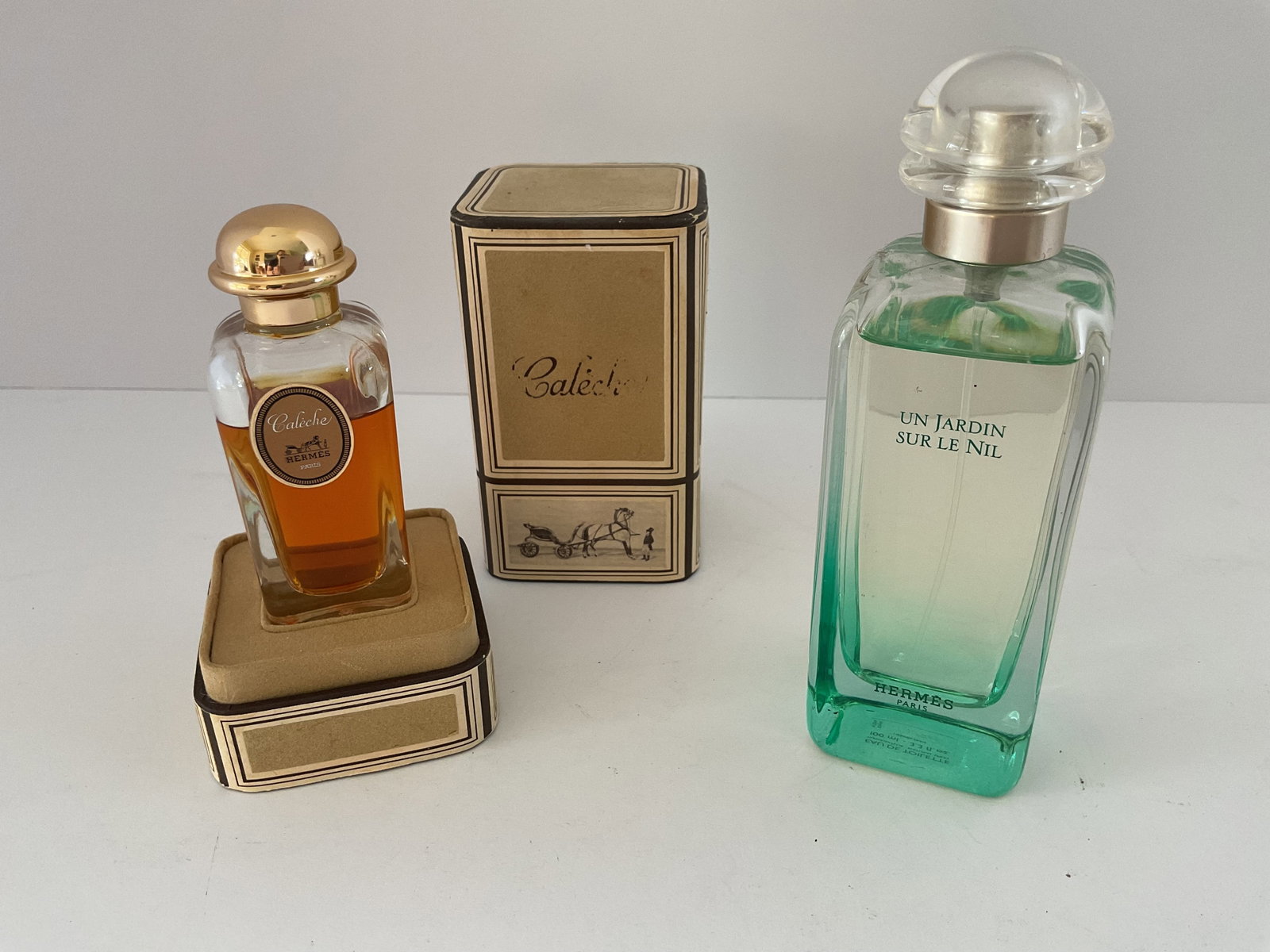 Two Hermes Perfume/Eau de Toilette: Two bottles of Hemes scents. Included is vintage Caleche .30ml perfume in the original packaging. Also included is Eau de Toilette “Jardin Sur Le Nil” 3.3 fluid ounce. Each is over 3/4 full
